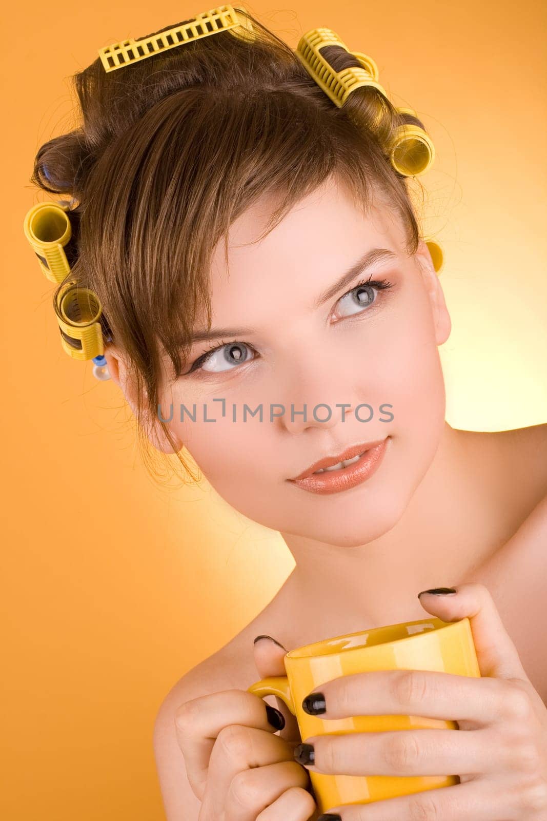 girl with hair-rollers holding a coffee cup
