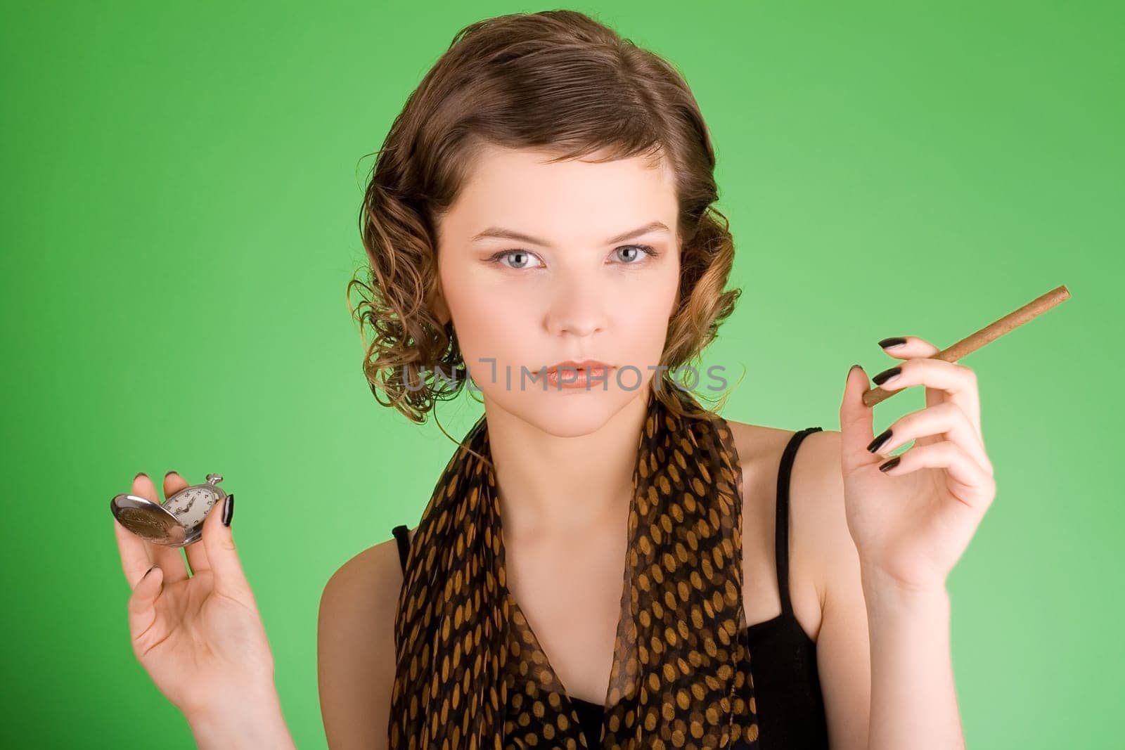 a glamorous girl in the evening dress holding the watch and a cigarette