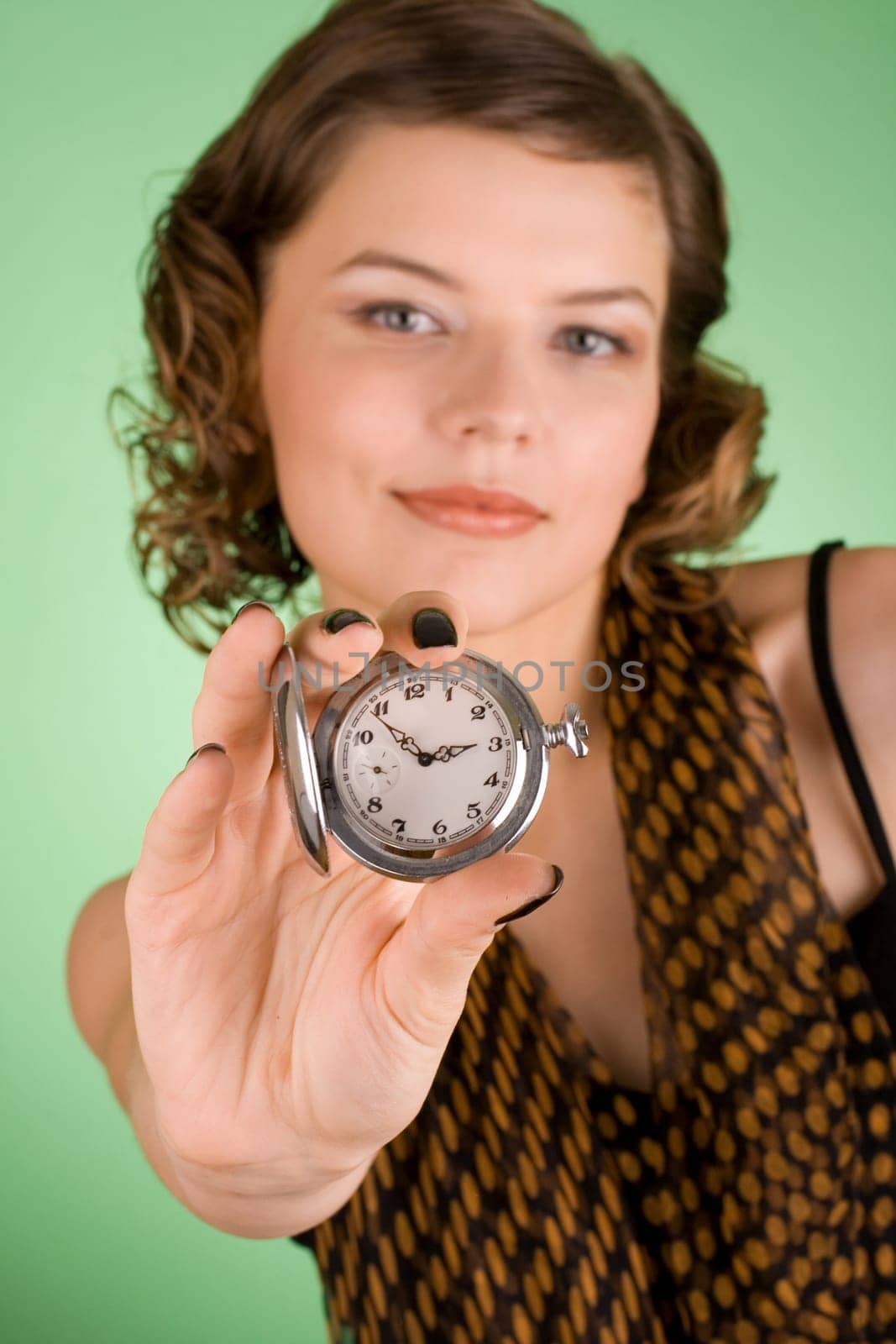 a glamorous girl in the evening dress holding the watch