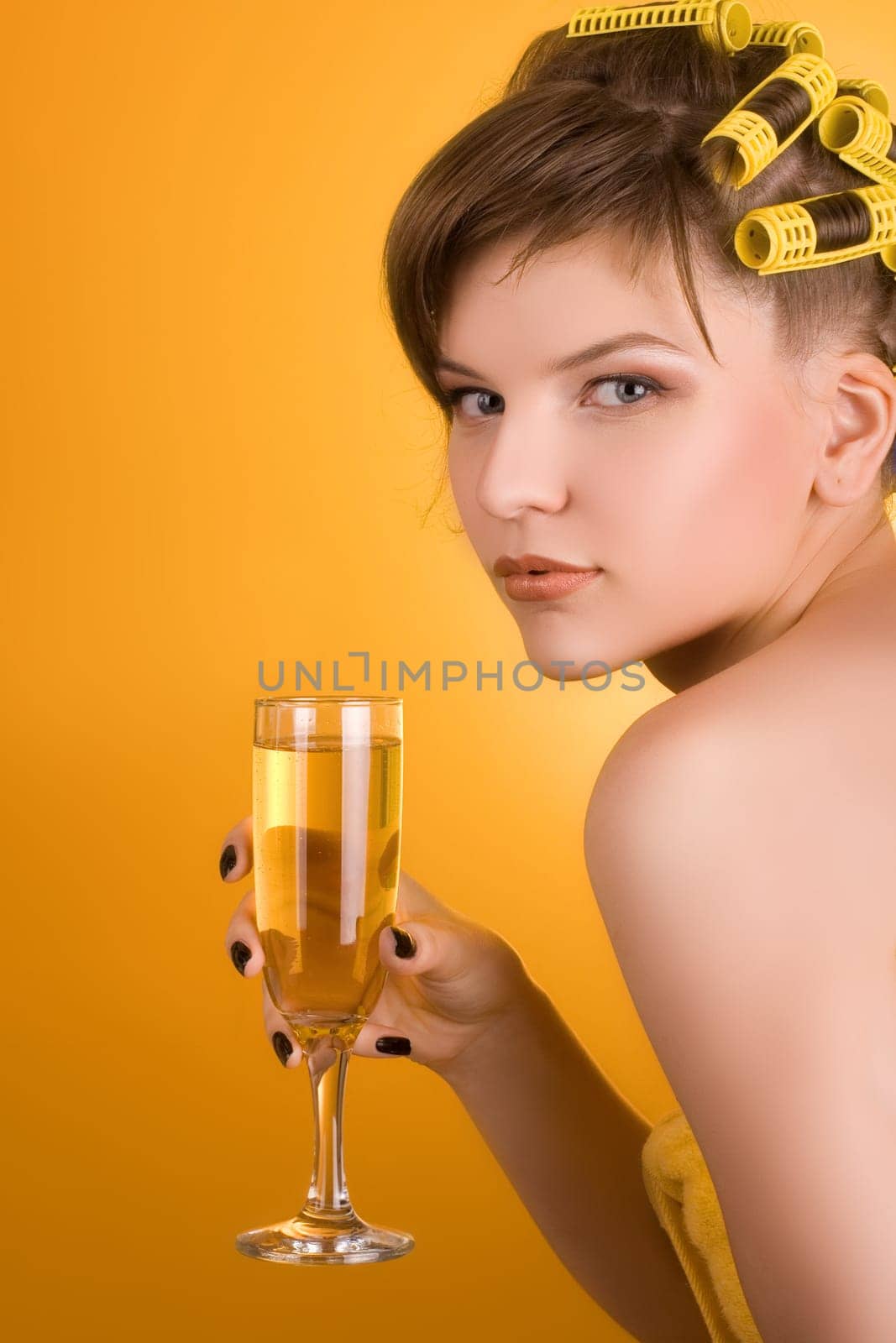 girl with hair-rollers holding a glass of wine