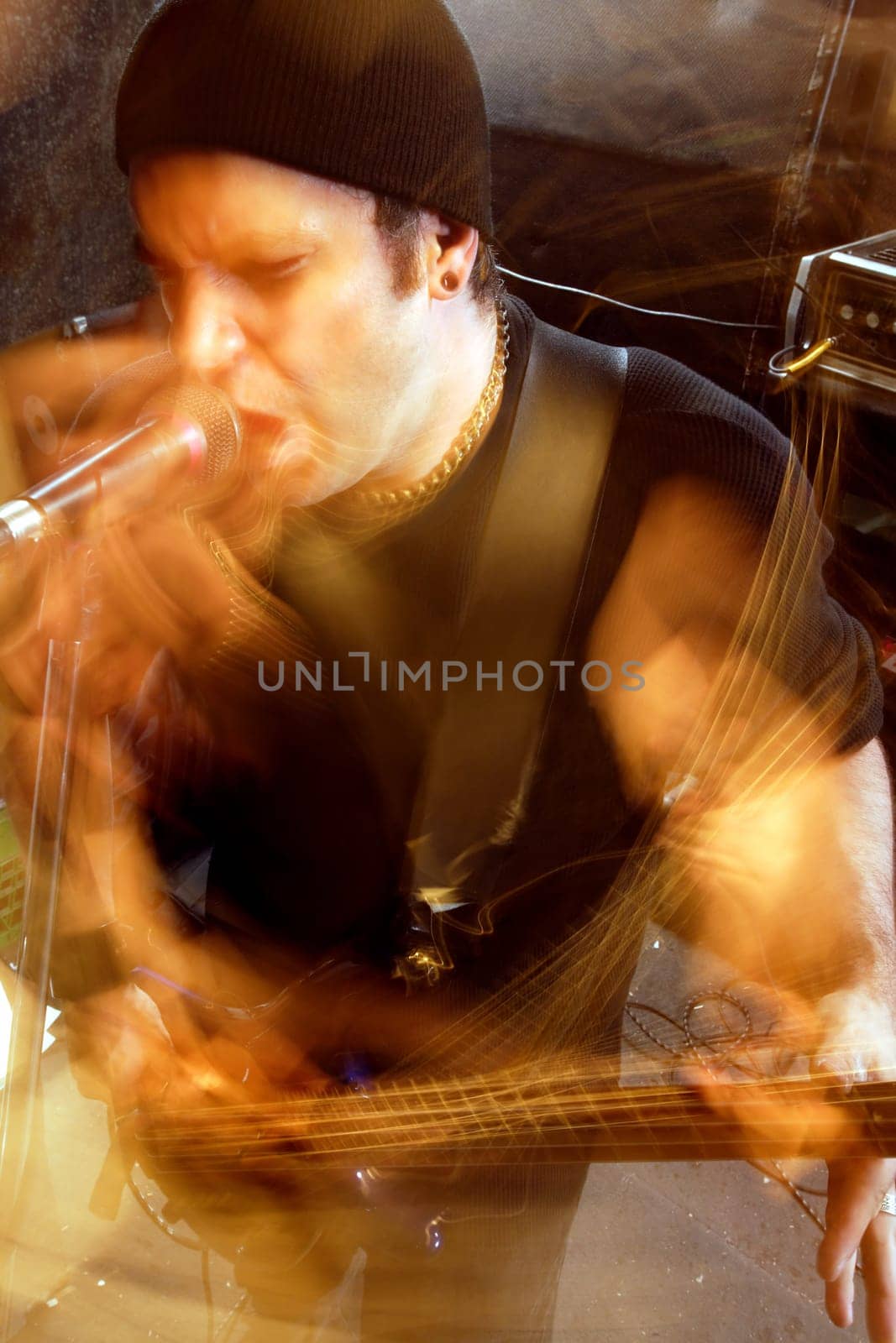 Blurry atmospheric abstract noisy hazy image of a bass player rippin' thru songs. Shot with slow shutter speed and flash for lots of movement and effect.