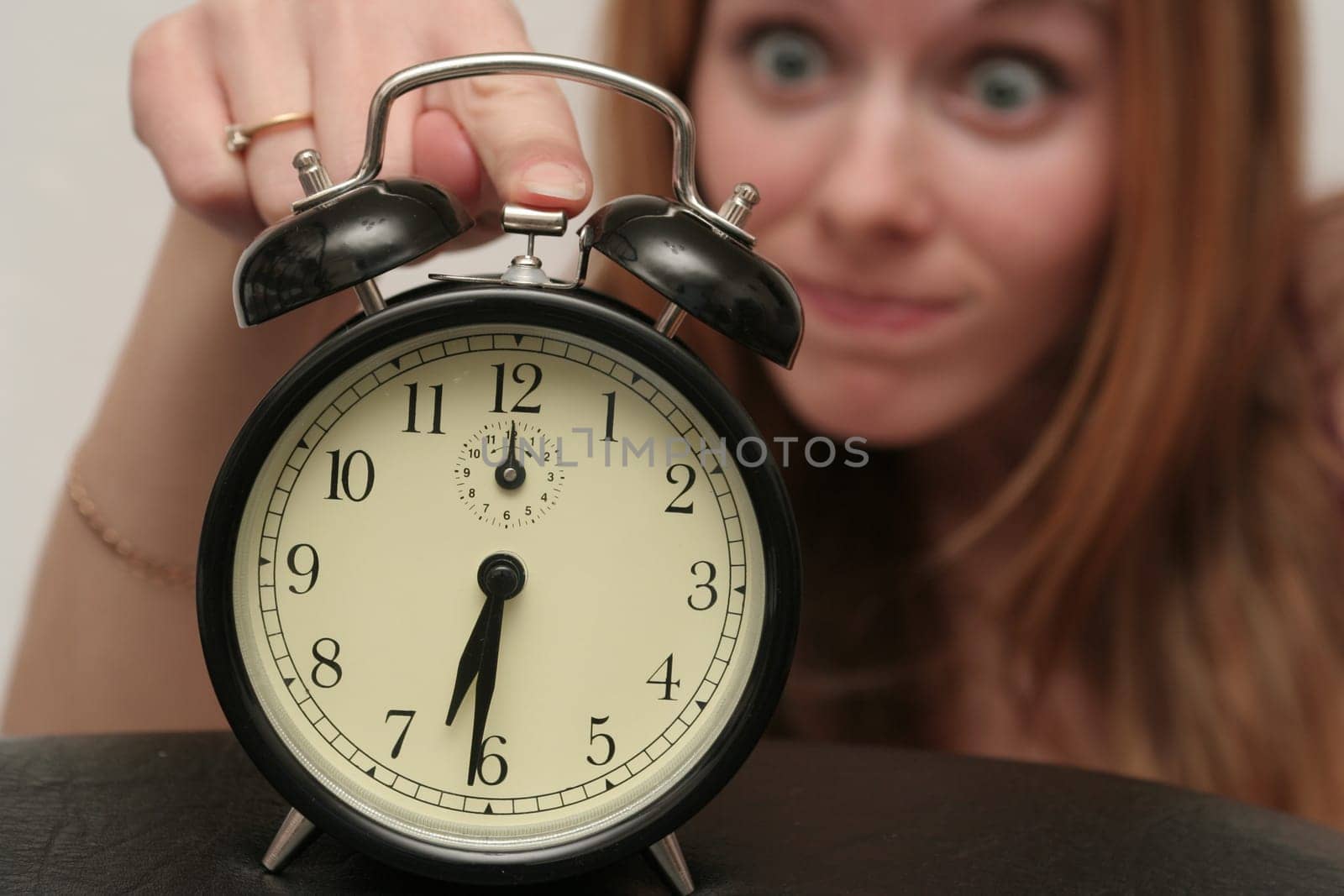 The black alarm clock has woken the girl