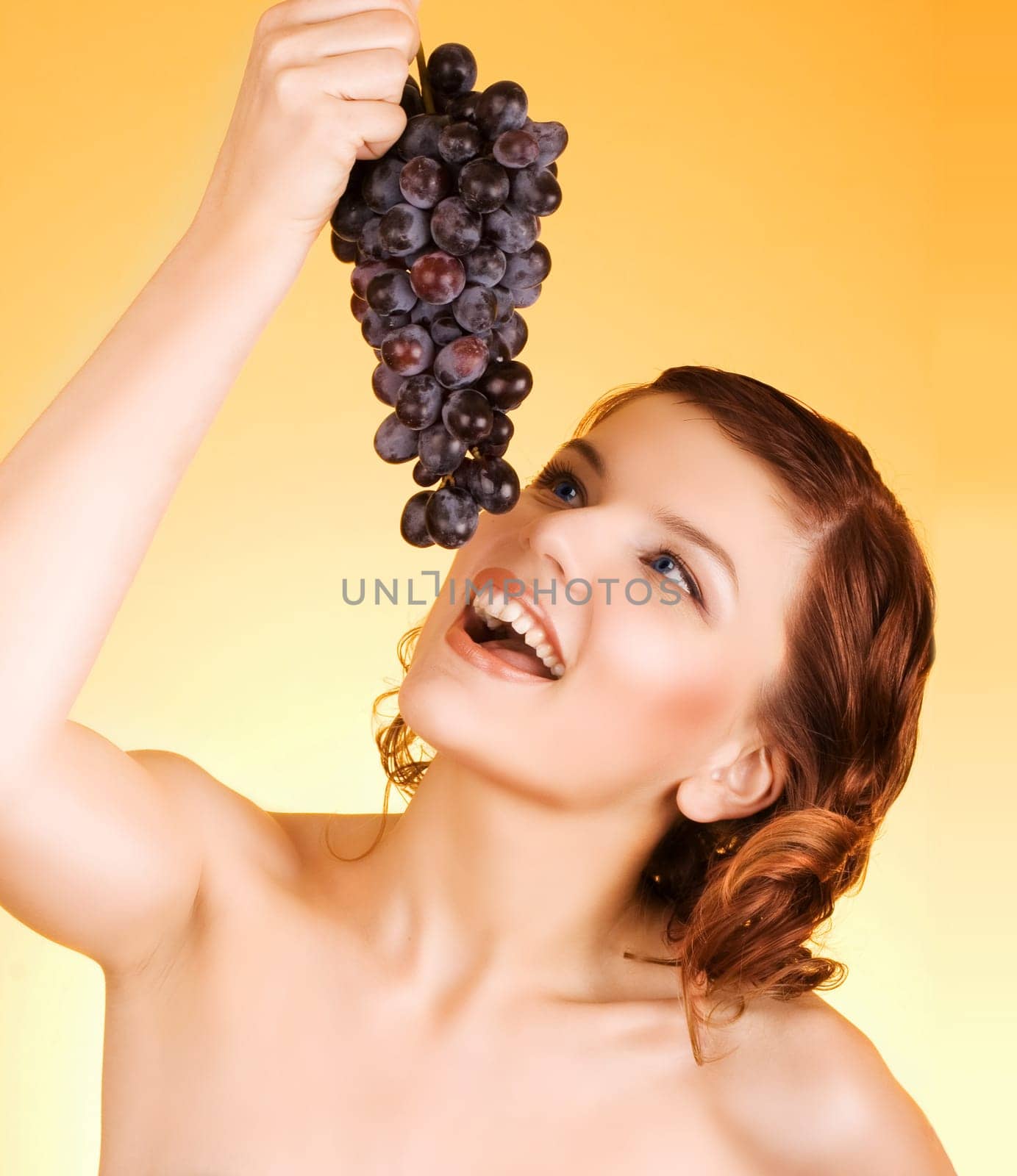 a glamorous girl holding some grapes in her hand