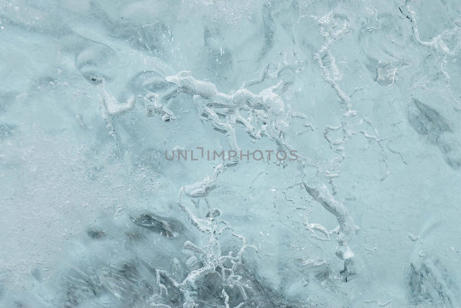 Patterns in a chunk of ice on a beach in Iceland. These chunks of ice fall from the glacier in the lake of Jokulsarlon and are flushed to sea. Most of them are thrown back on the beach before they become water again.