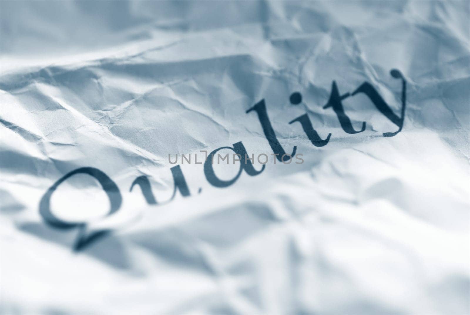 quality word on a wrinkled sheet of paper