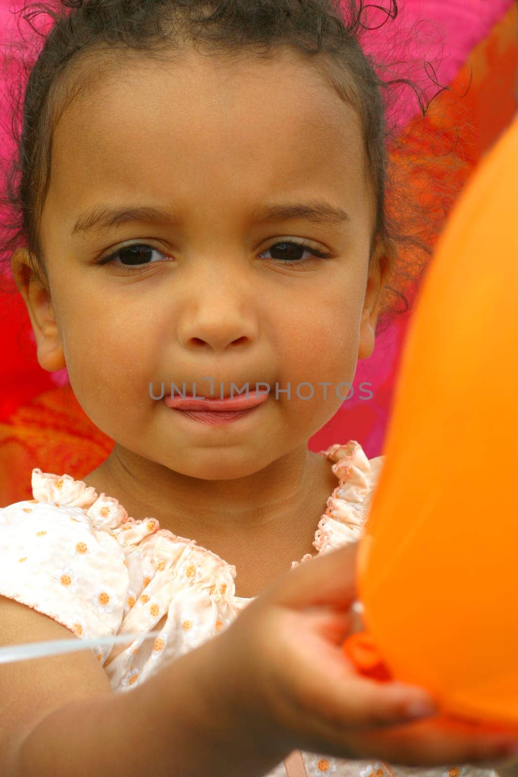 A beautiful mixed race little girl holding a balloon