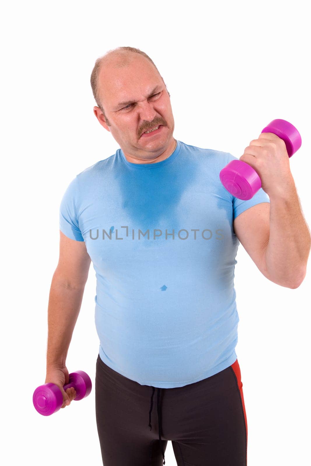 Mature male trying to lift one kilo weights with a lot of effort