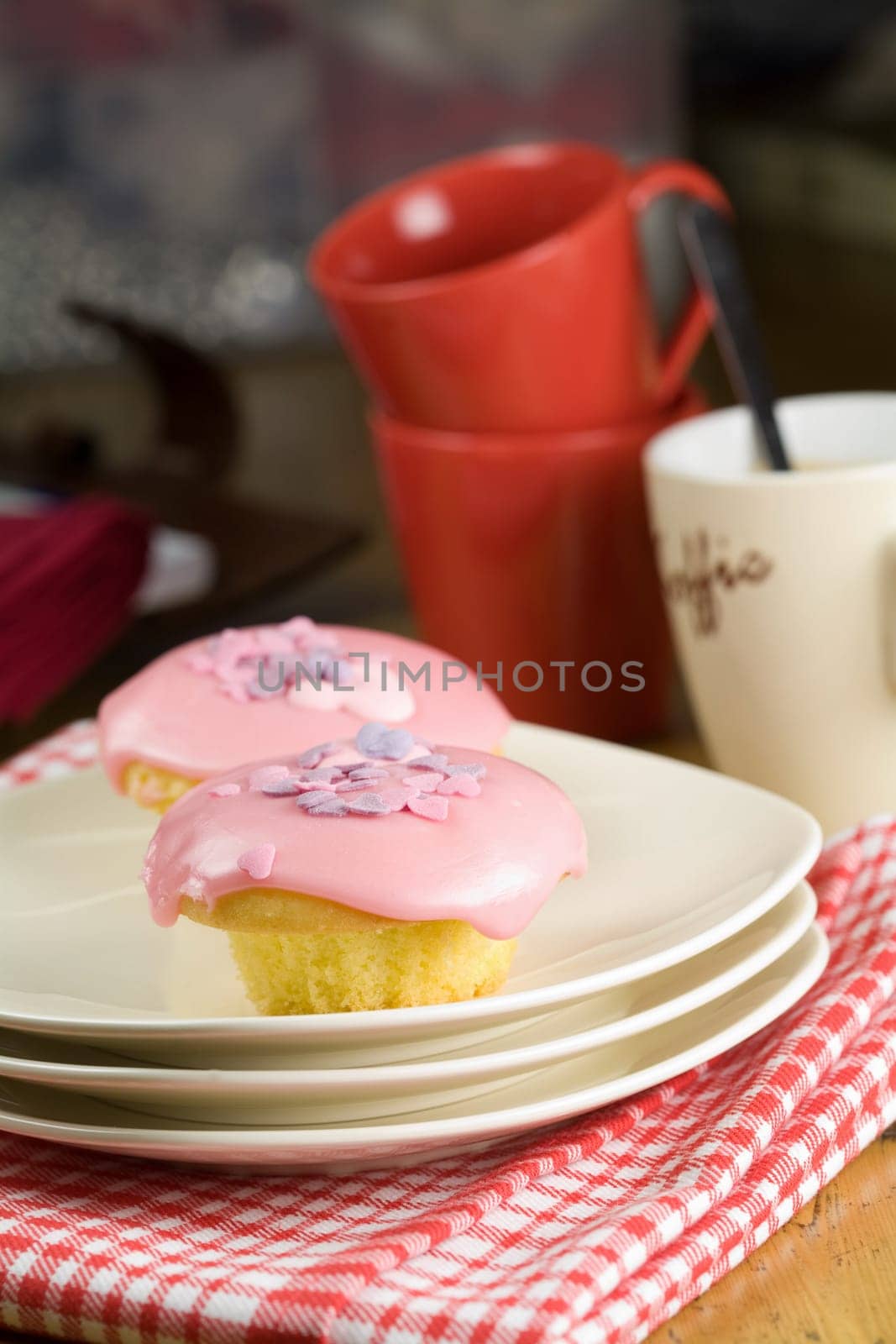 Cupcakes with coffee cups in the background (text on cup means coffee in dutch)