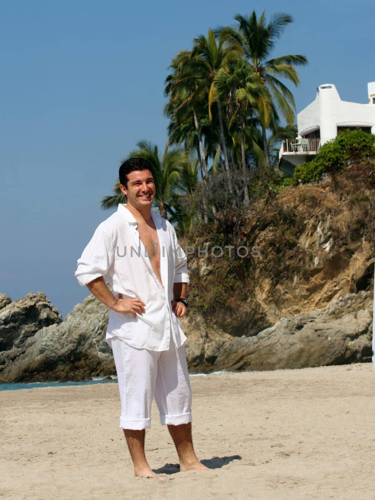 Young man in white clothes on the beach