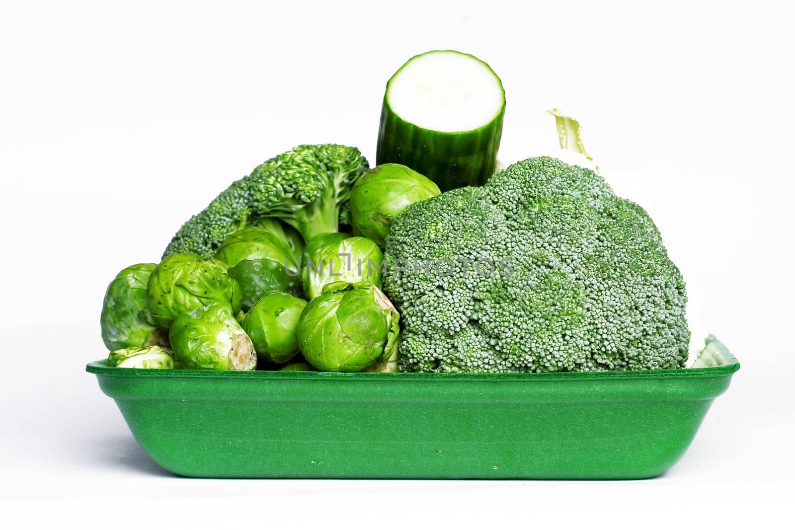 Green tray with vegetables isolated on white