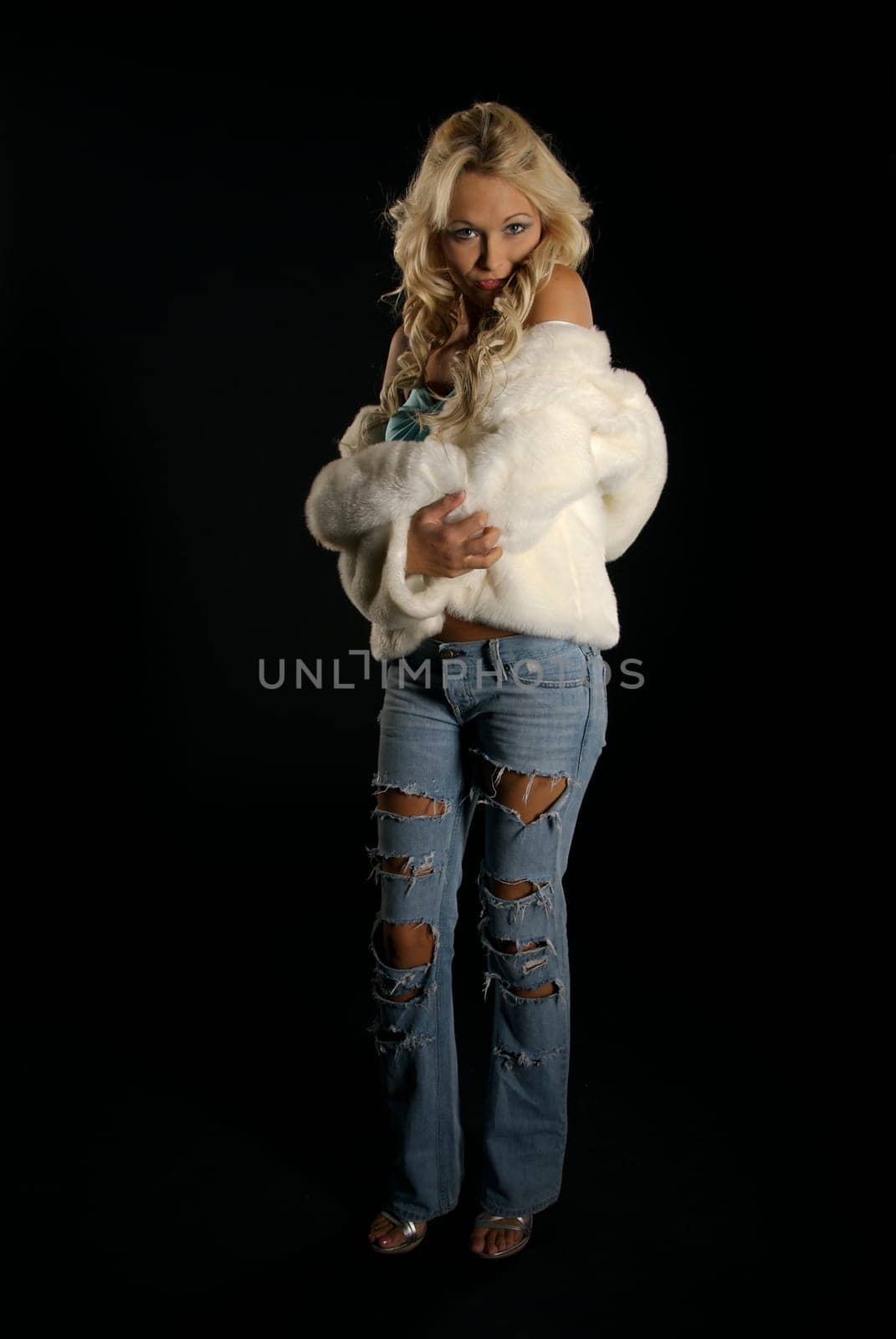 Pretty young woman posing against a black background.