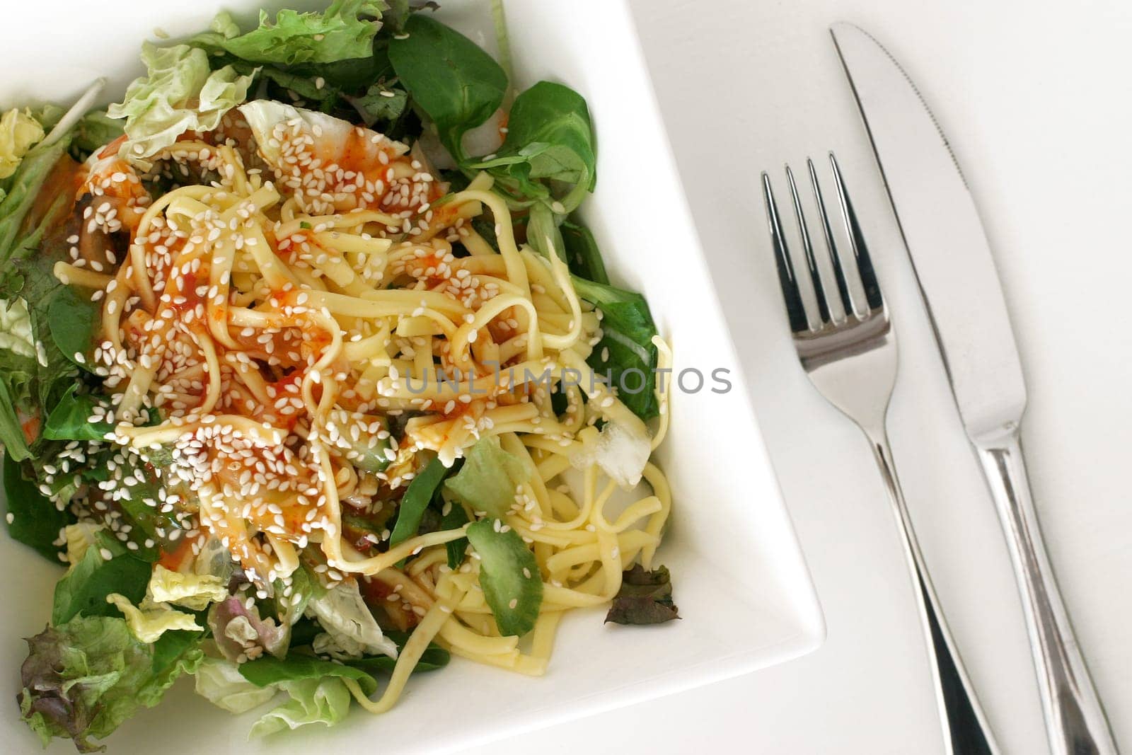 a healthy green salad with shrimps and noodles