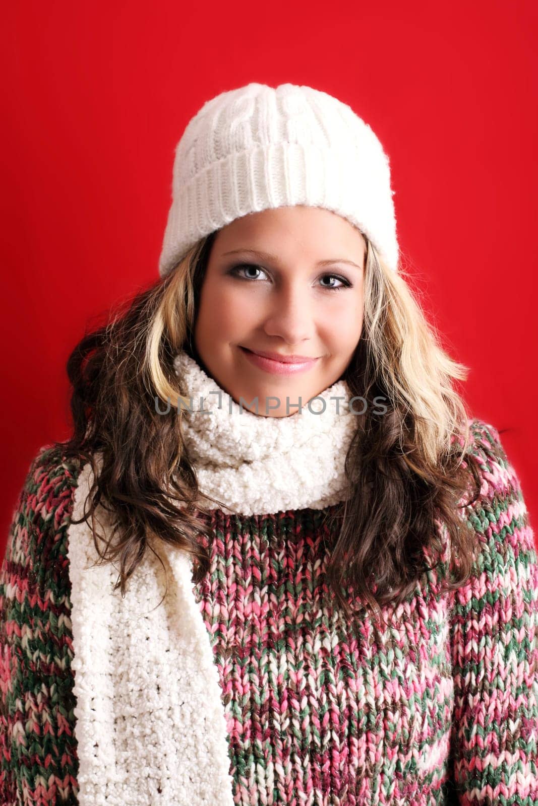 winter portrait of a beautiful young woman is freezing with a cap and a scarf