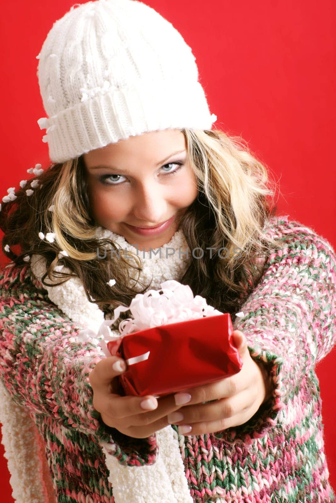 winter portrait of a beautiful young smiling woman with a gift in her hands