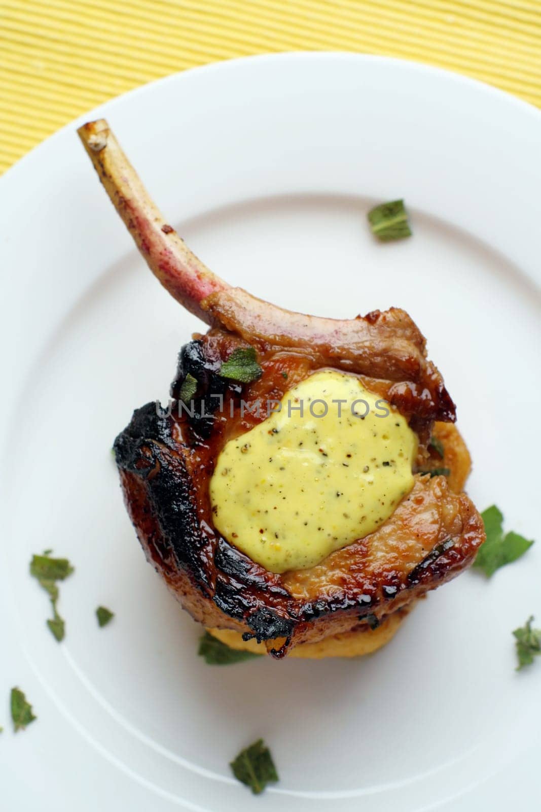 Pan fried pork cutlet on a tomato capsicum cous-cous with lime aioli (lime, olive oil, and egg) coriander garnish.