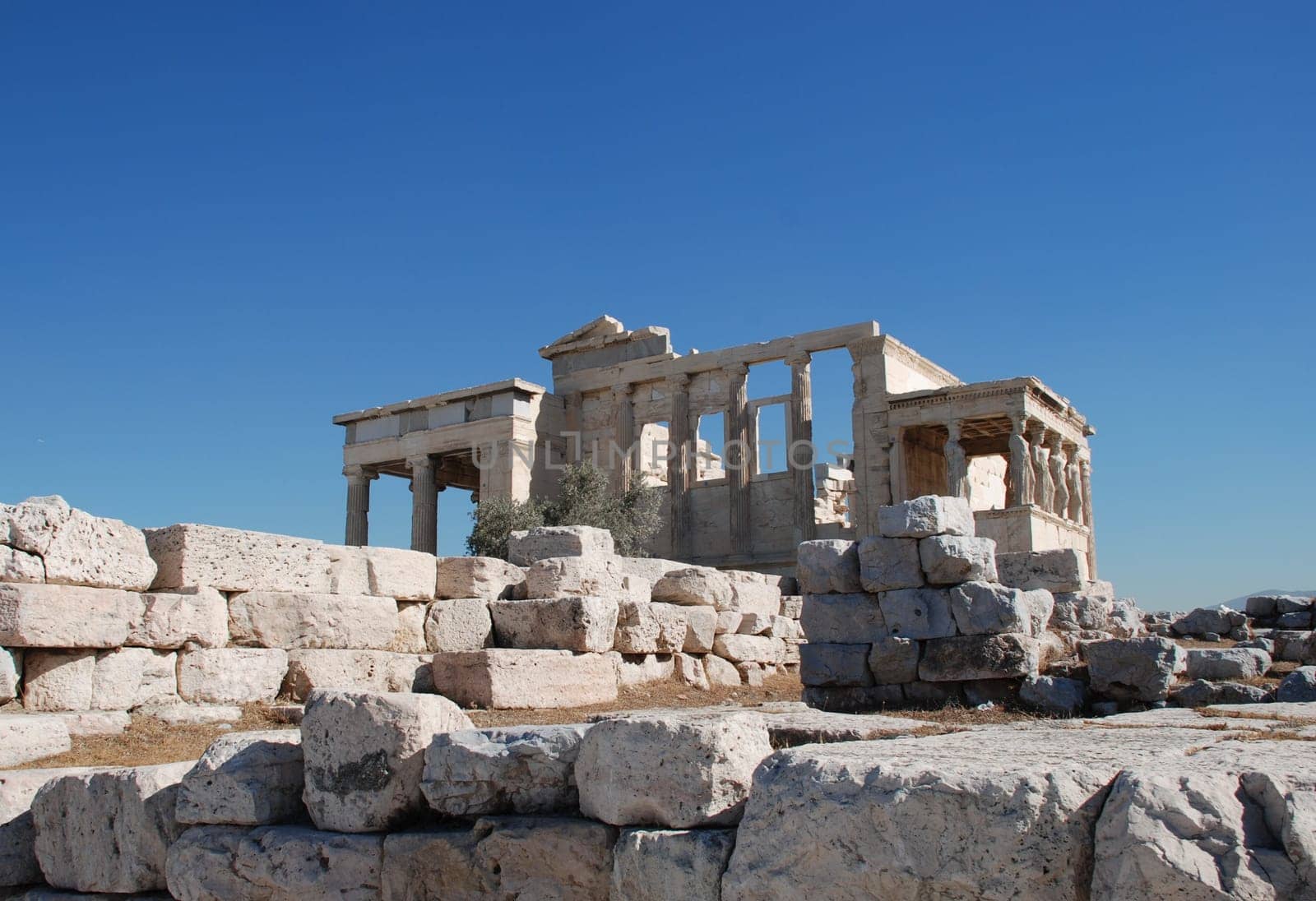 The Erecthion sits on the most sacred site of the Acropolis where Poseidon and Athena had their contest over who would be the Patron of the city. Poseidon thrust his trident into the rock and a spring burst forth, while Athena touched the ground with a sp