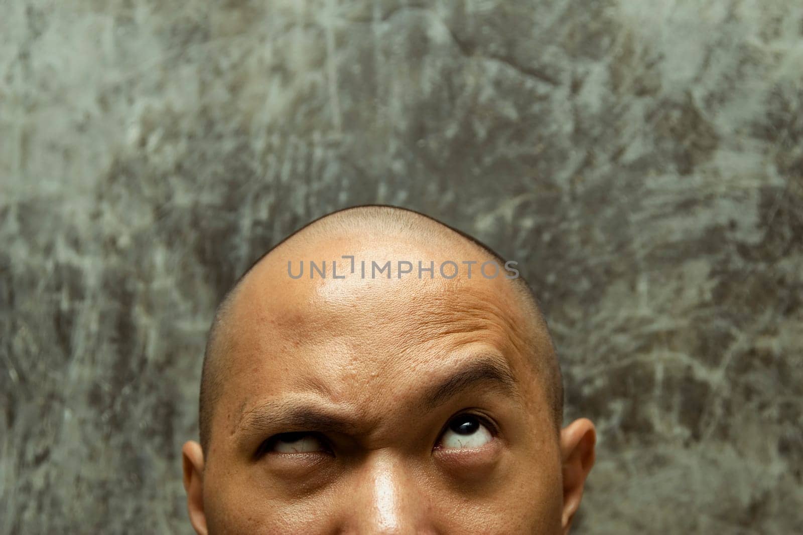 close up photo of a bald headed man with confuse expression