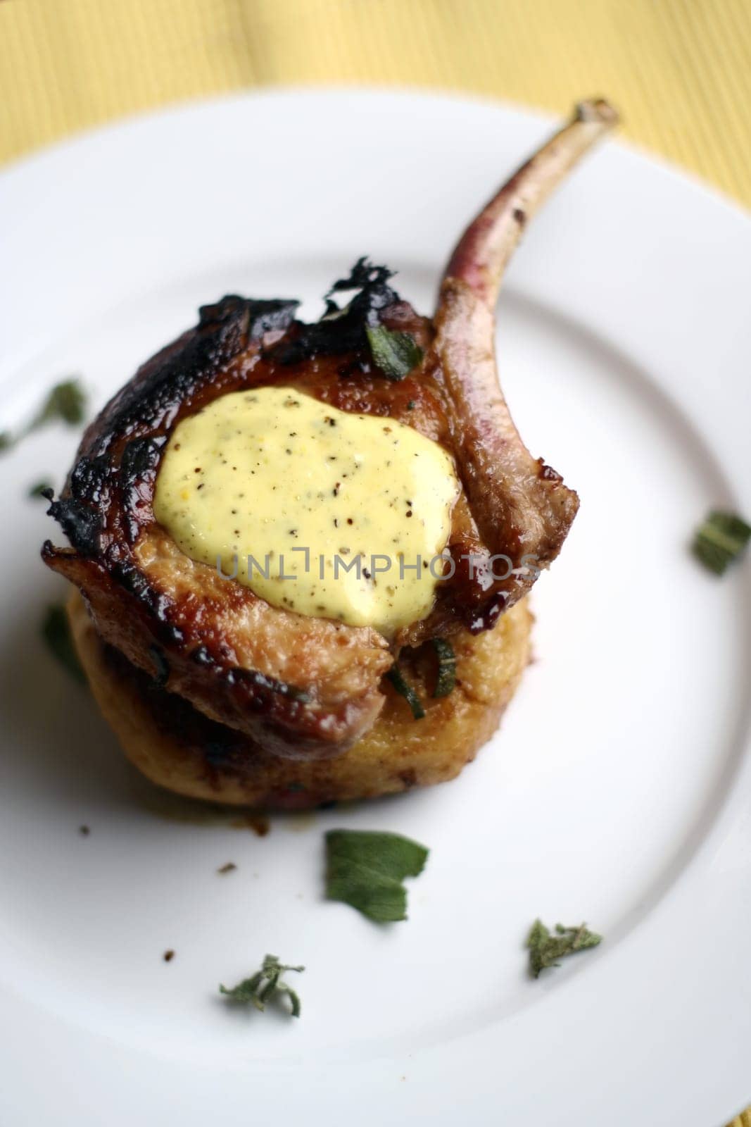 Pan fried pork cutlet on a tomato capsicum cous-cous with lime aioli (lime, olive oil, and egg) coriander garnish.