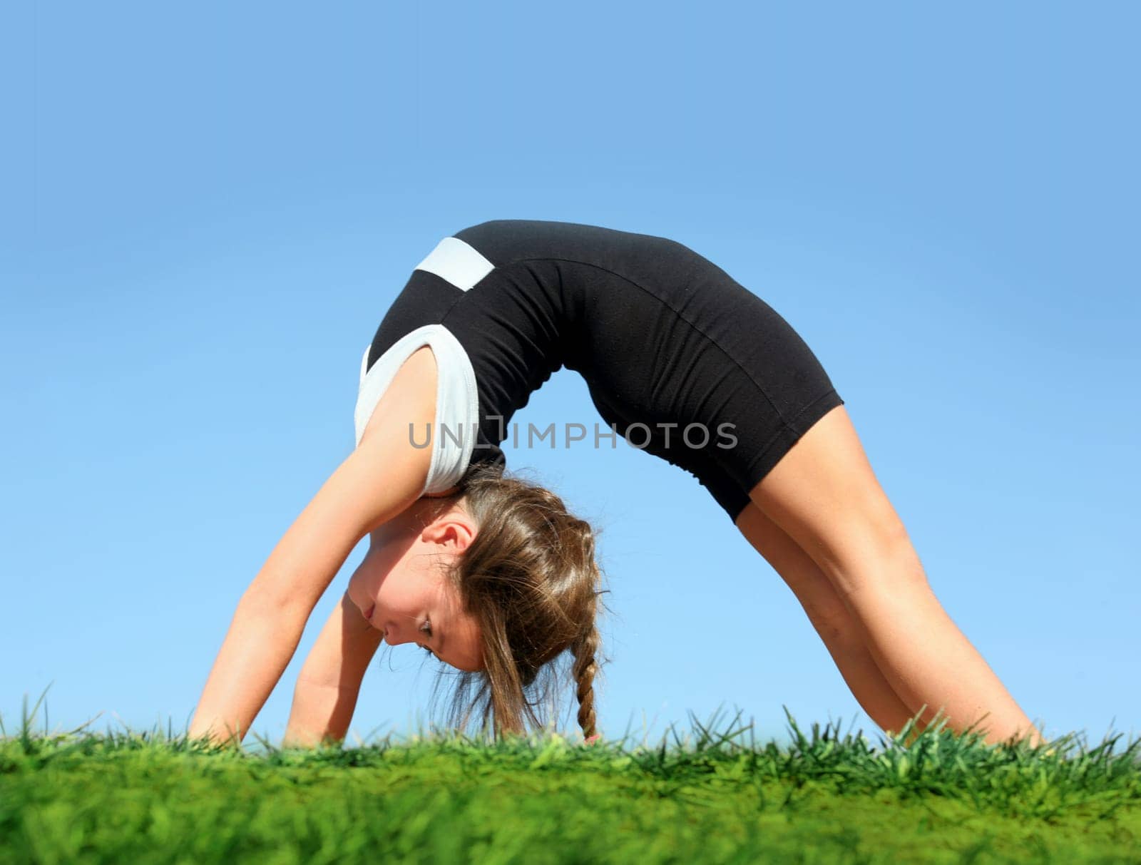 Cute girl doing bridge in the park