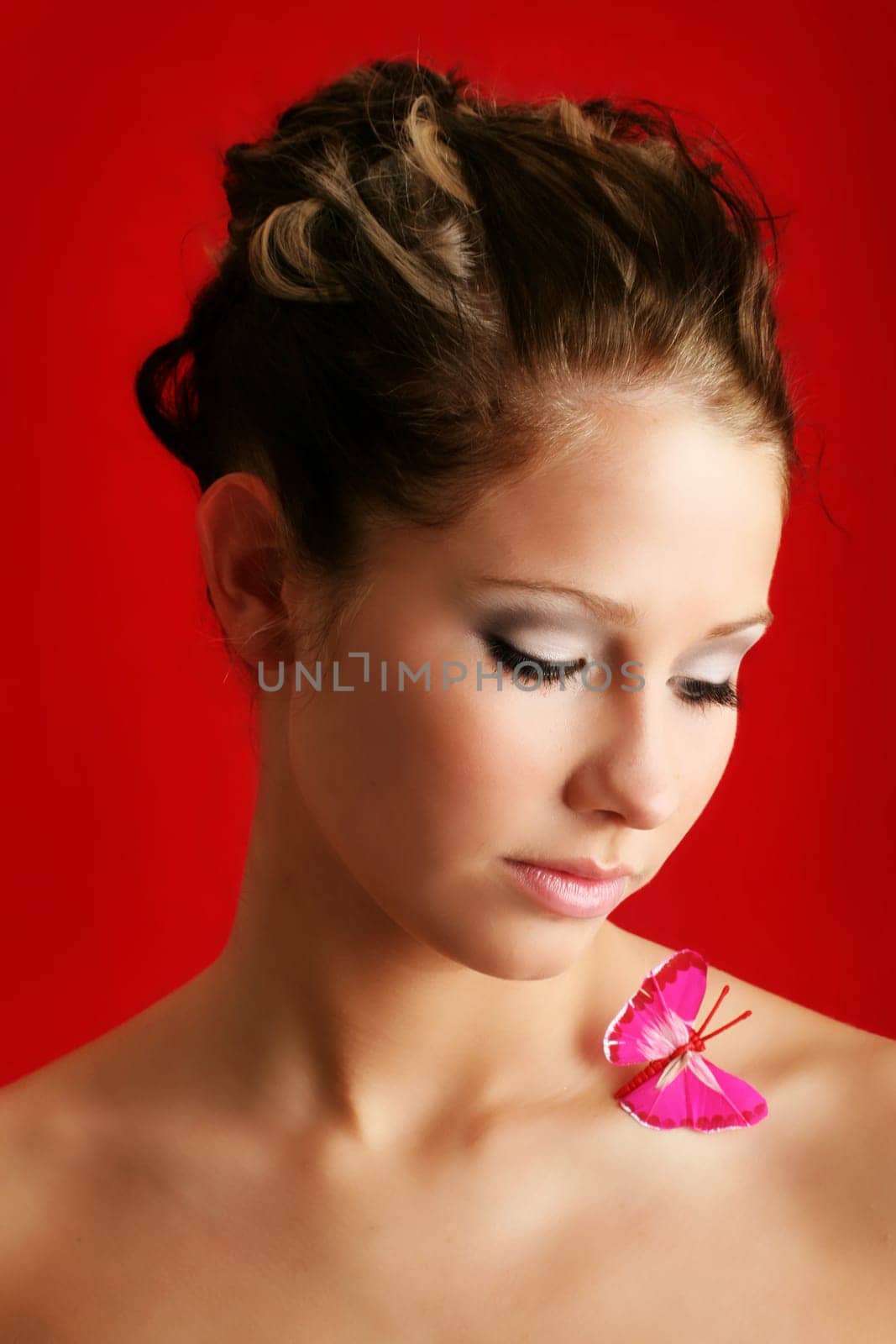beauty portrait of a beautiful young woman with a butterfly on her shoulder