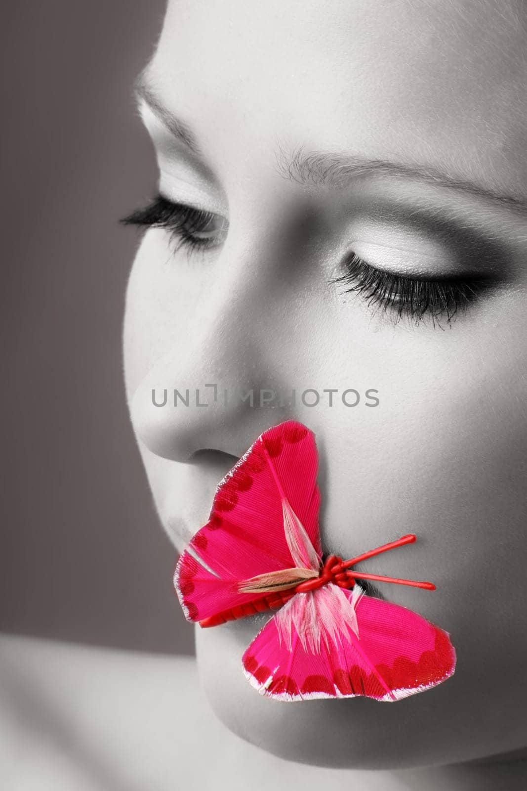 beauty portrait of a beautiful young woman with a butterfly on her lips