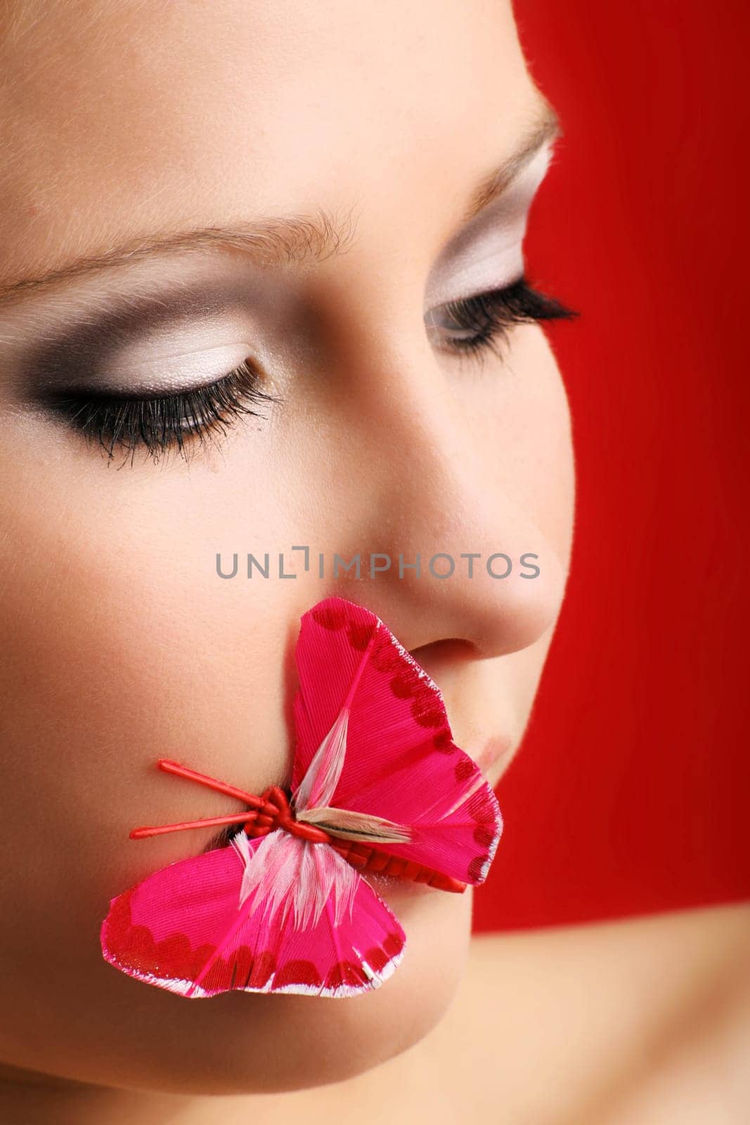 beauty portrait of a beautiful young woman with a butterfly on her lips
