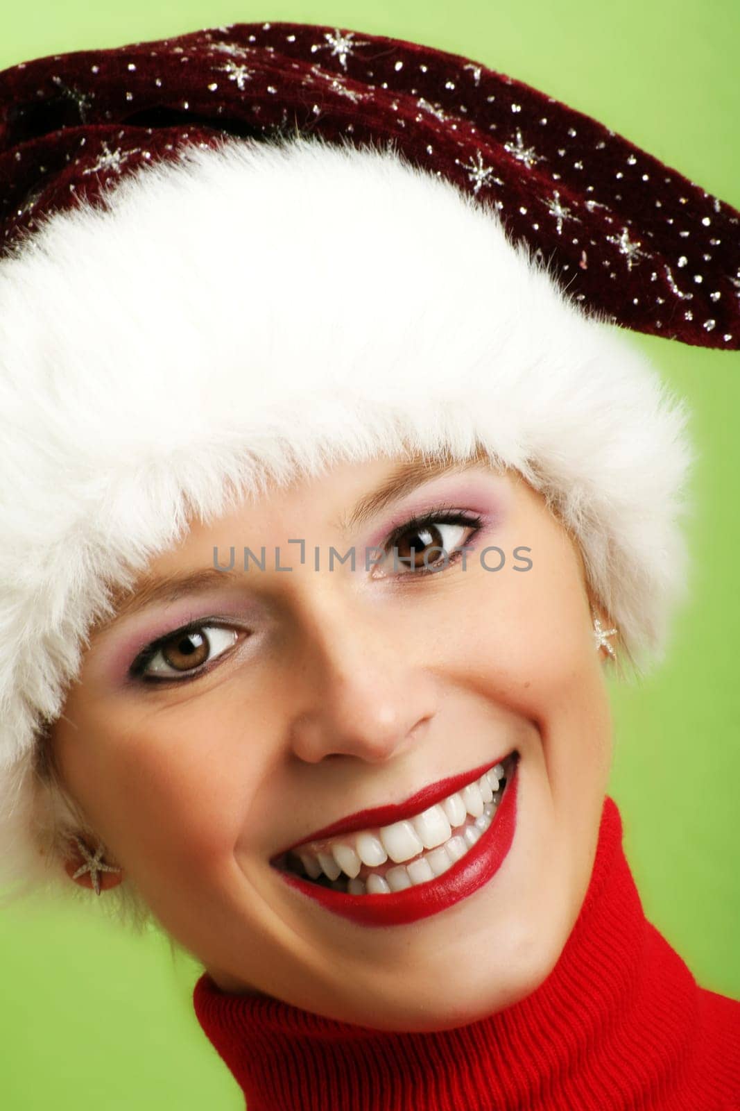 winter portrait of a beautiful young smiling woman with a christmas cap
