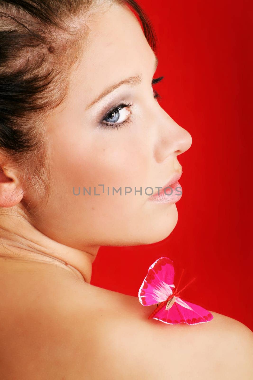 beauty portrait of a beautiful young woman with a butterfly on her shoulder