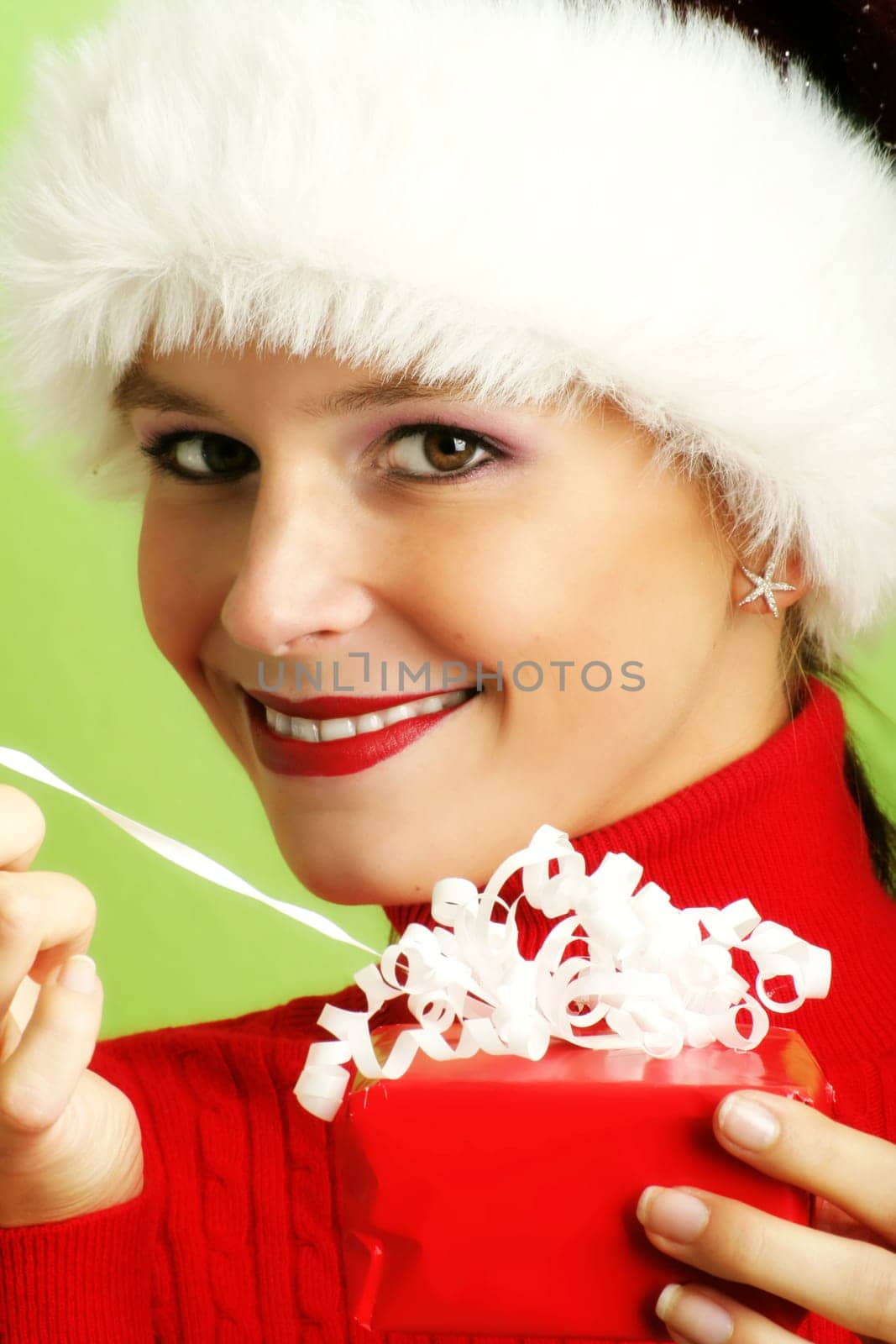 winter portrait of a beautiful young smiling woman with a gift in her hand
