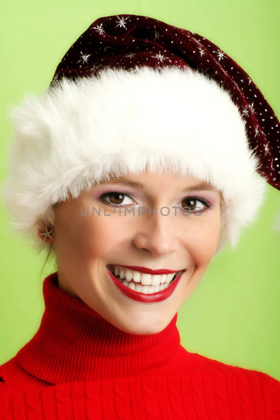 winter portrait of a beautiful young smiling woman with a christmas cap