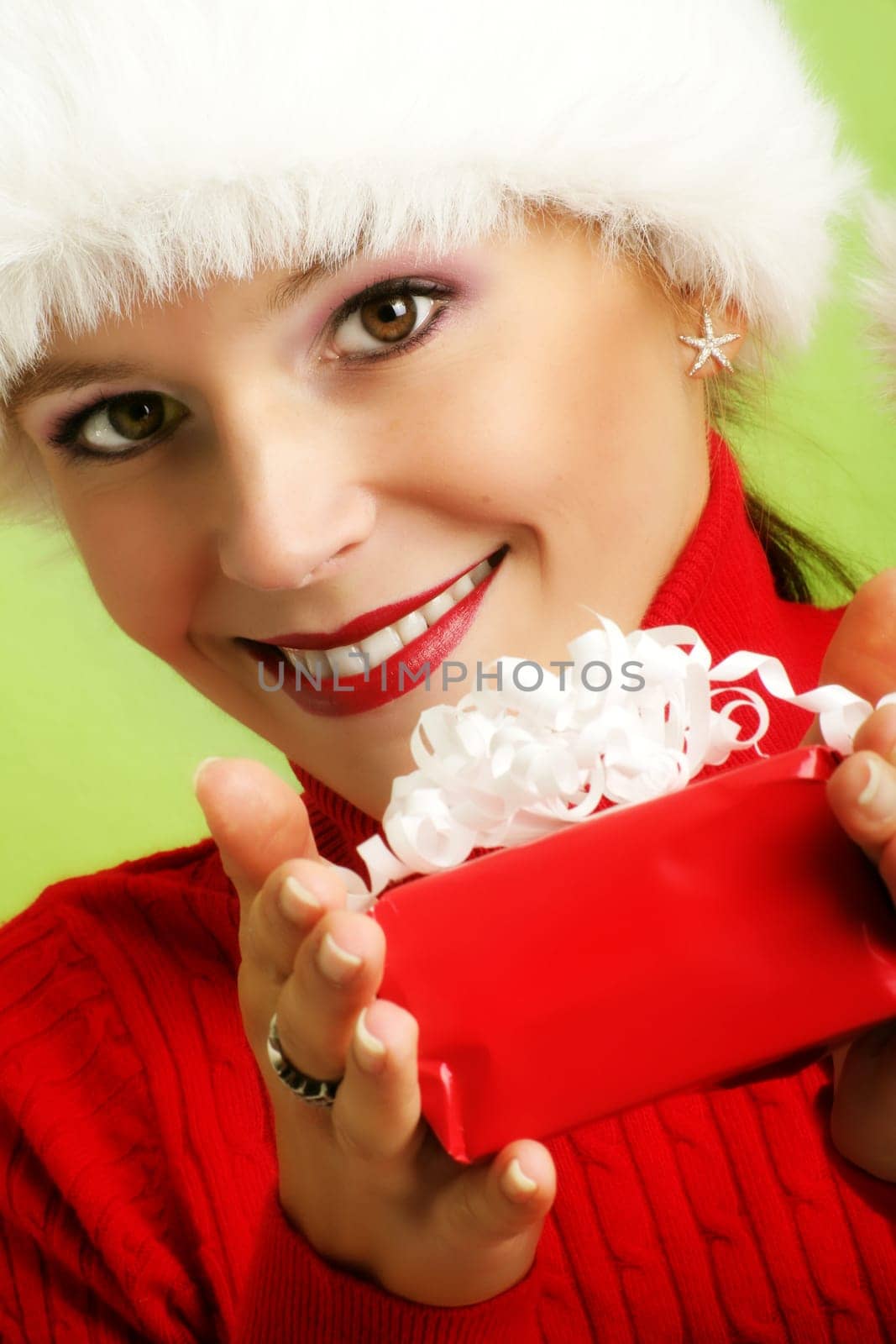winter portrait of a beautiful young smiling woman with a gift in her hand