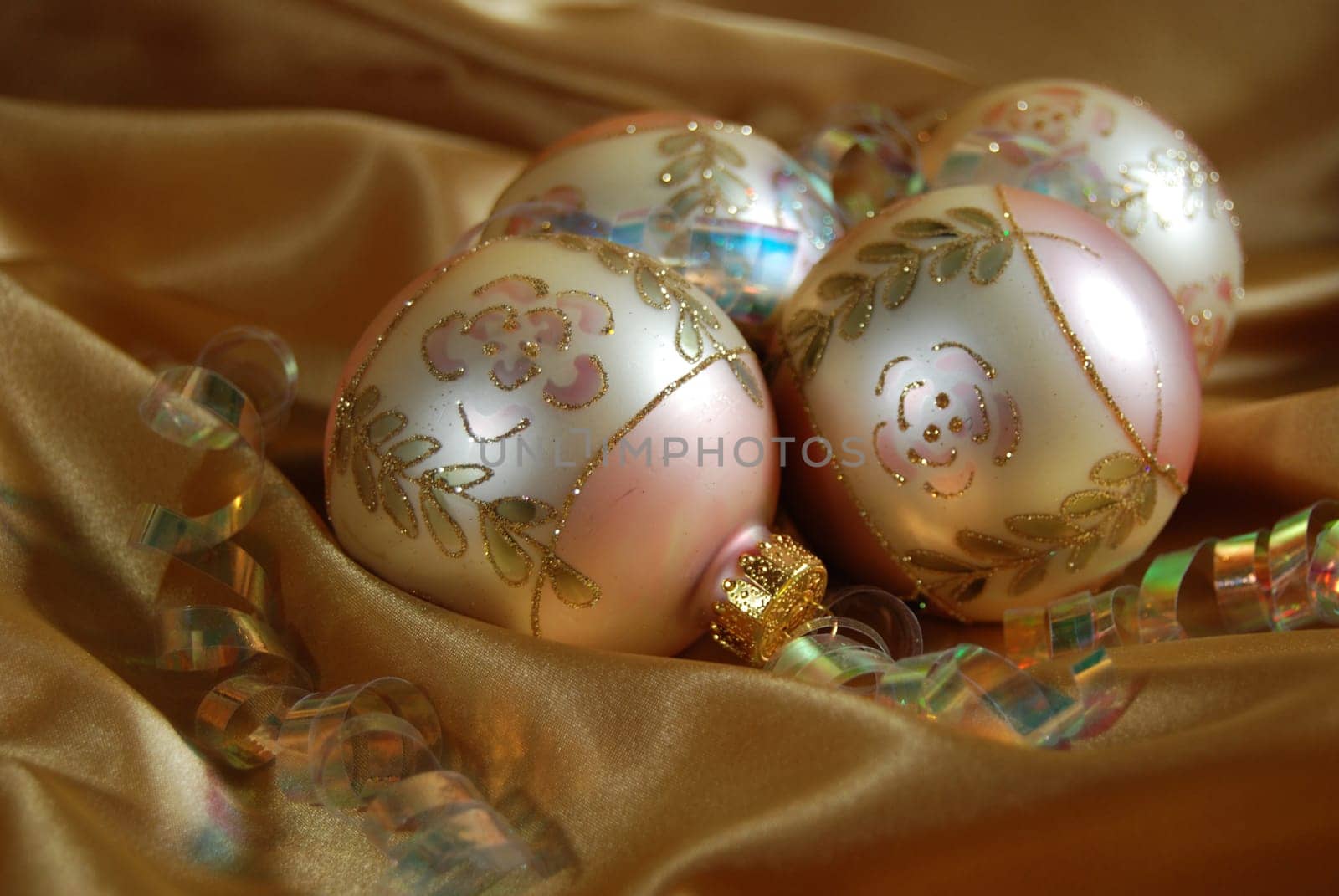 Christmas ornaments and ribbon on gold satin.