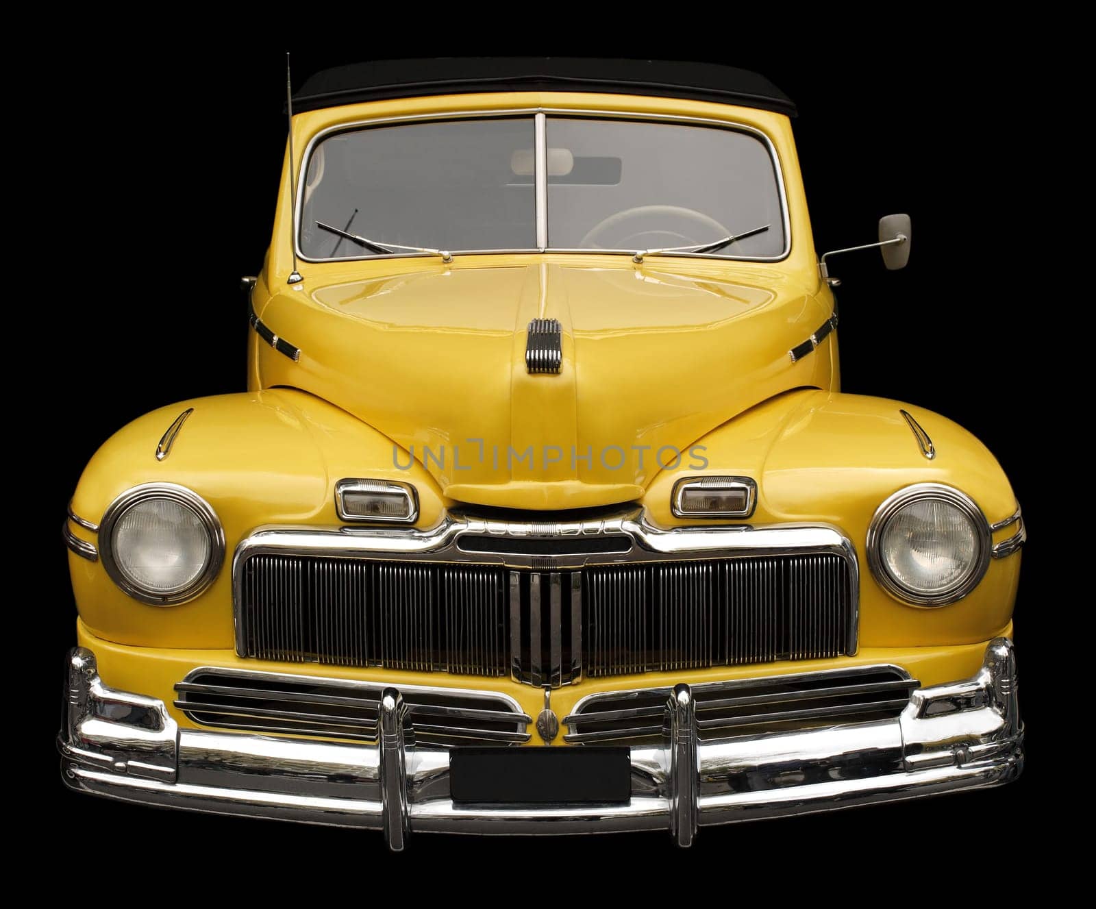 The grill, hood and headlamps of an antique classic car.