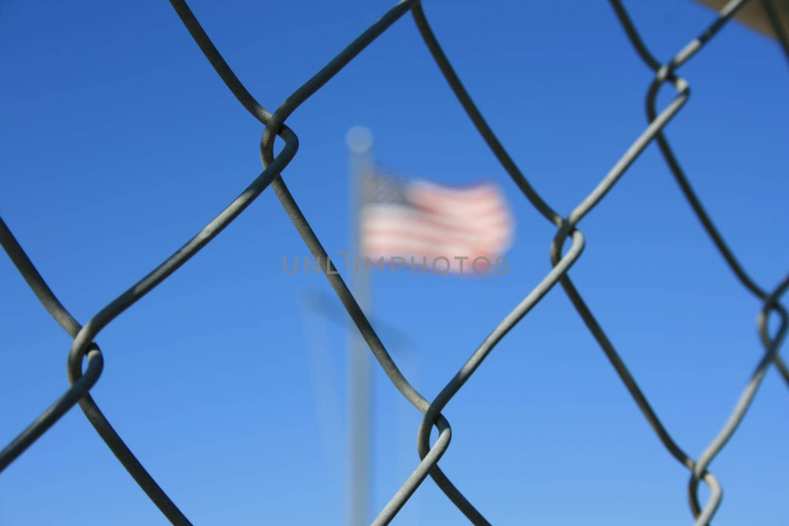 American flag behind a chain link fence.