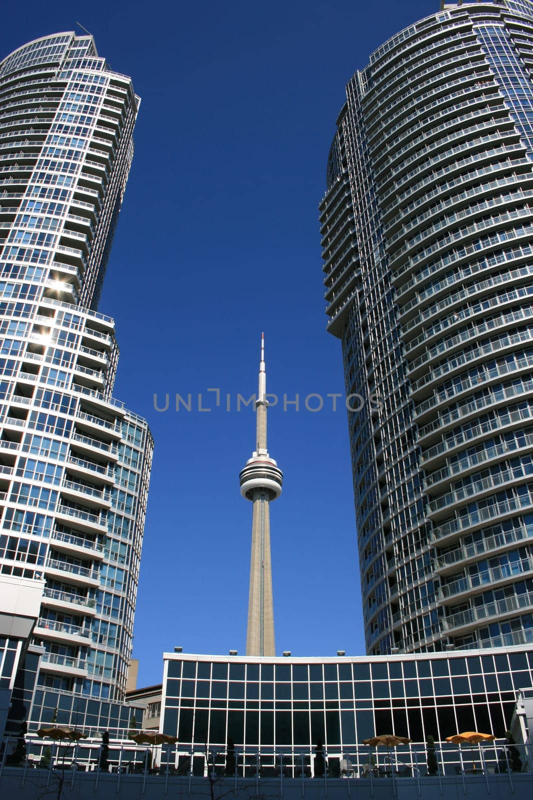 Toronto's CN Tower behind a pair of modern buildings.