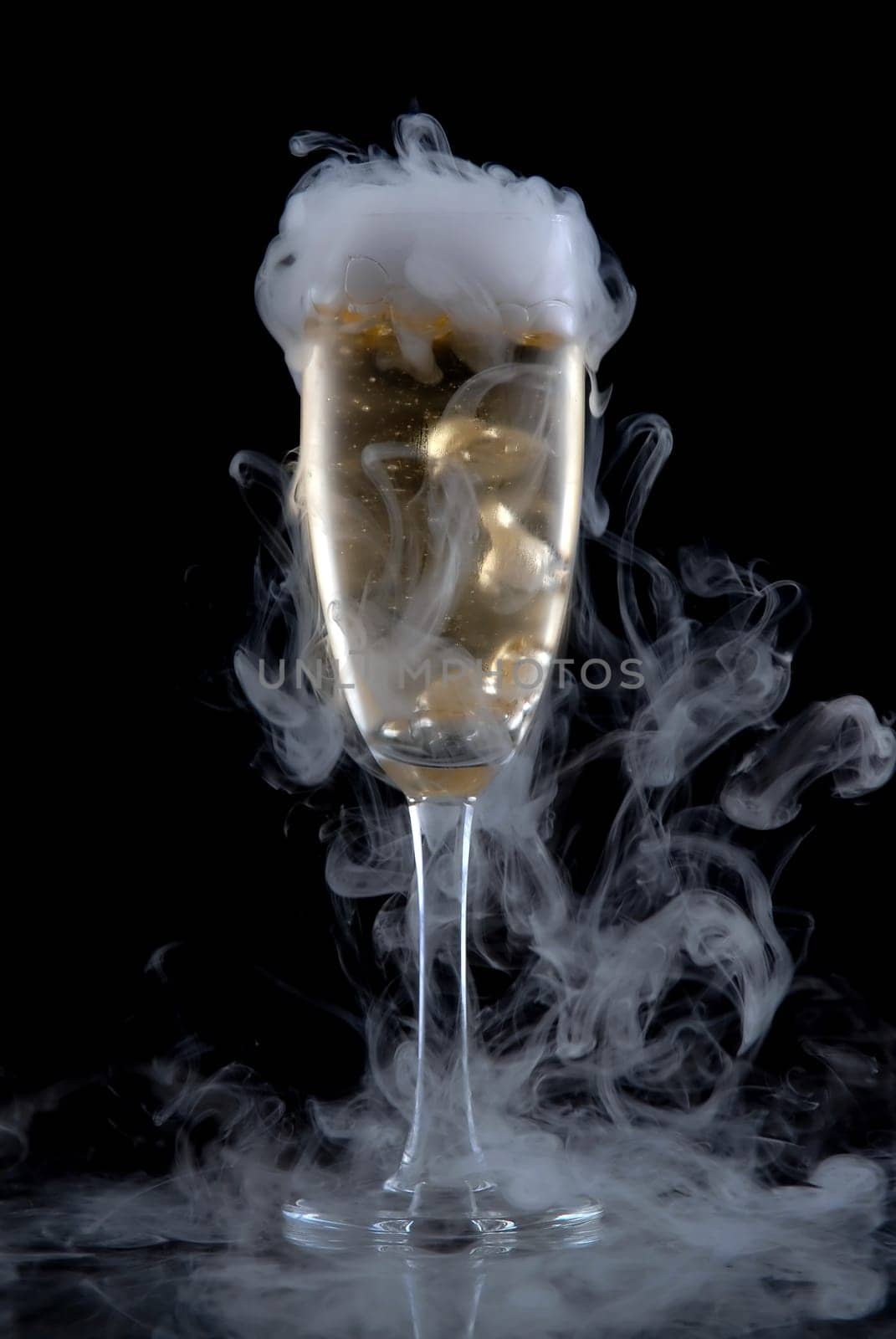 Glass of white wine isolated over black background, with a lot of smoke