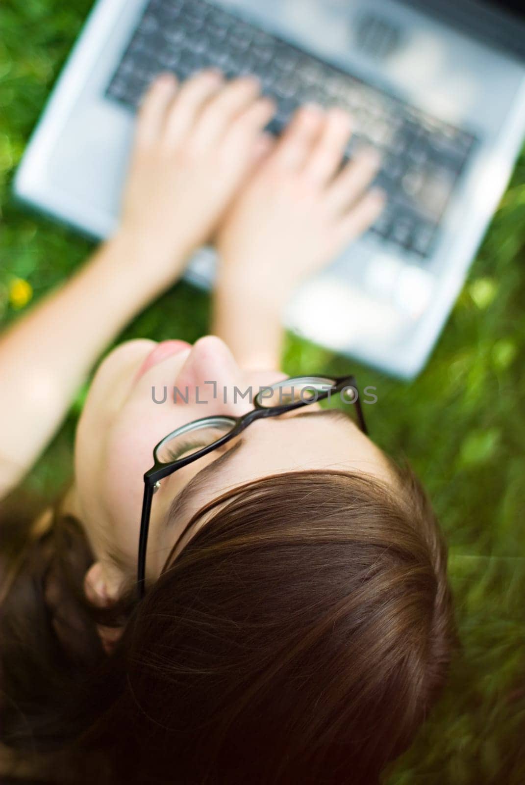 portrait of young woman surfing the internet outdoors on her notebook