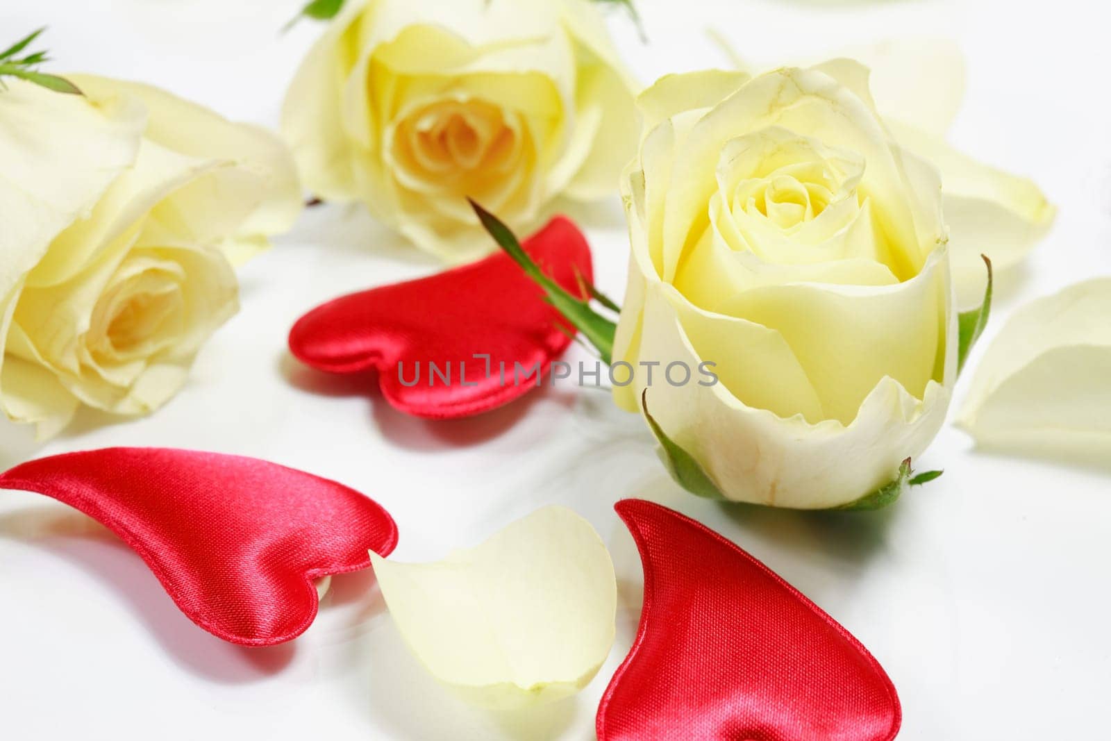 Red hearts and yellow roses on white background