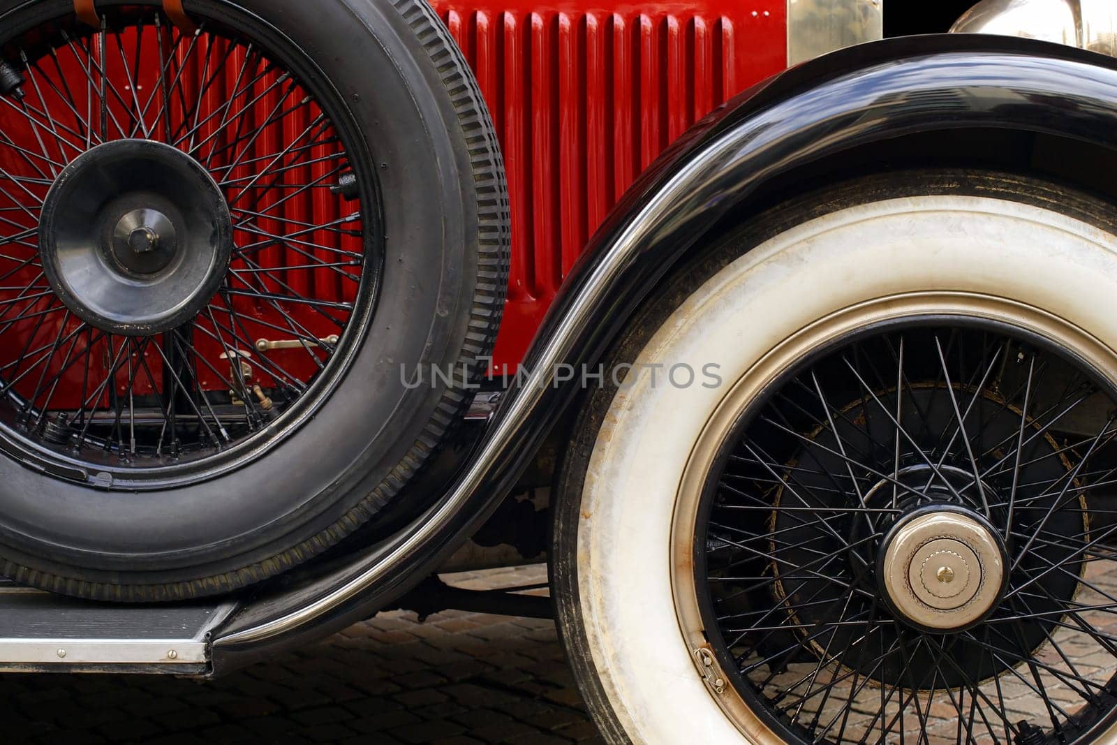 The fender and spoked wheels of an antique classic car.