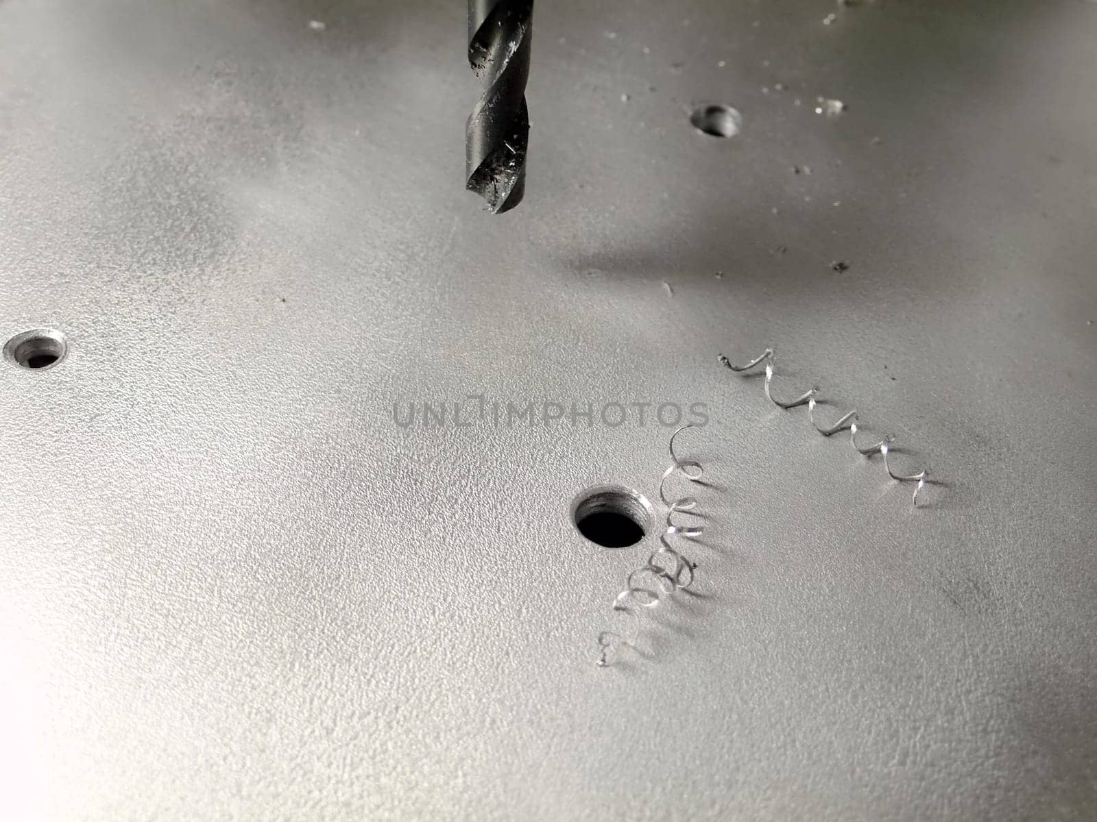 drilling holes, flat metallic board with spokeshaves and drill