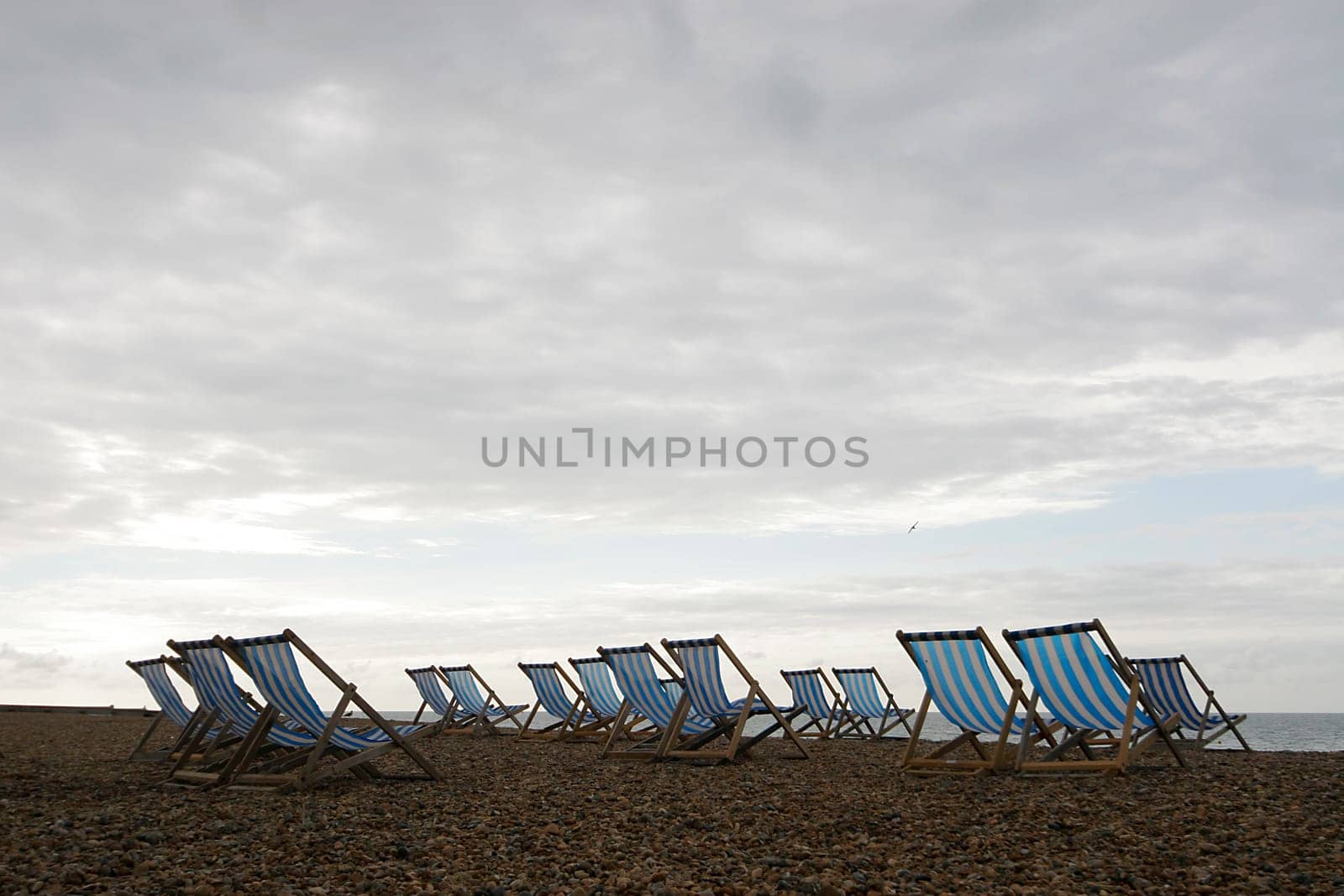 Deck chairs set out on an English beach just waiting for the sun