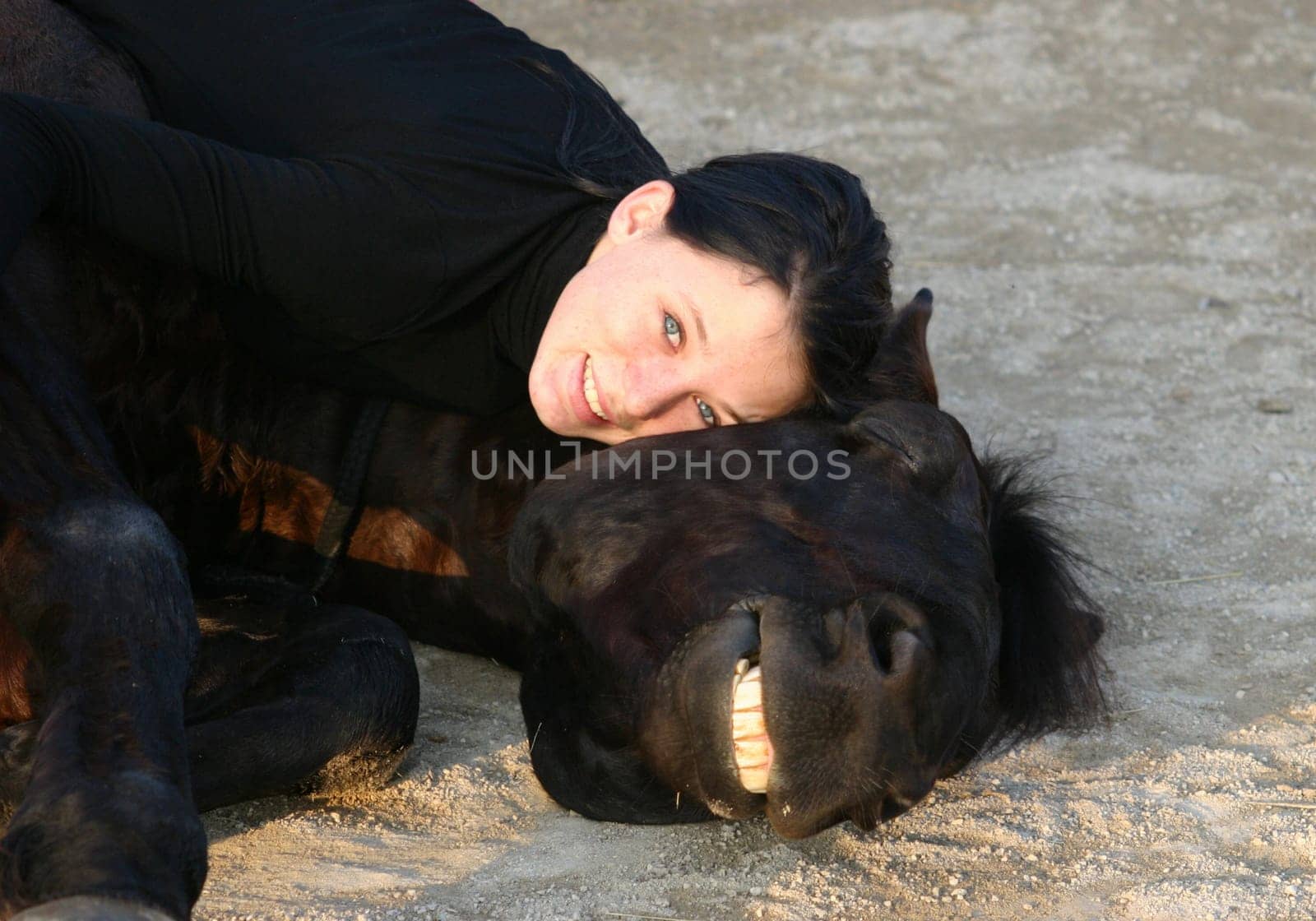 smiling horse and happy teen laid down together