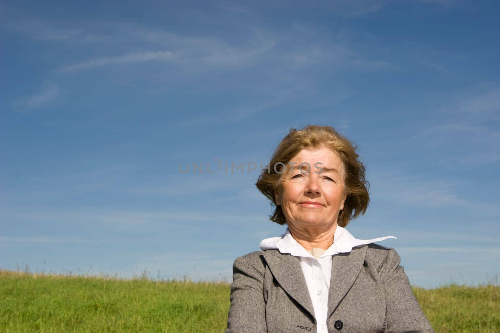Beautiful, joyful mature woman on the meadow