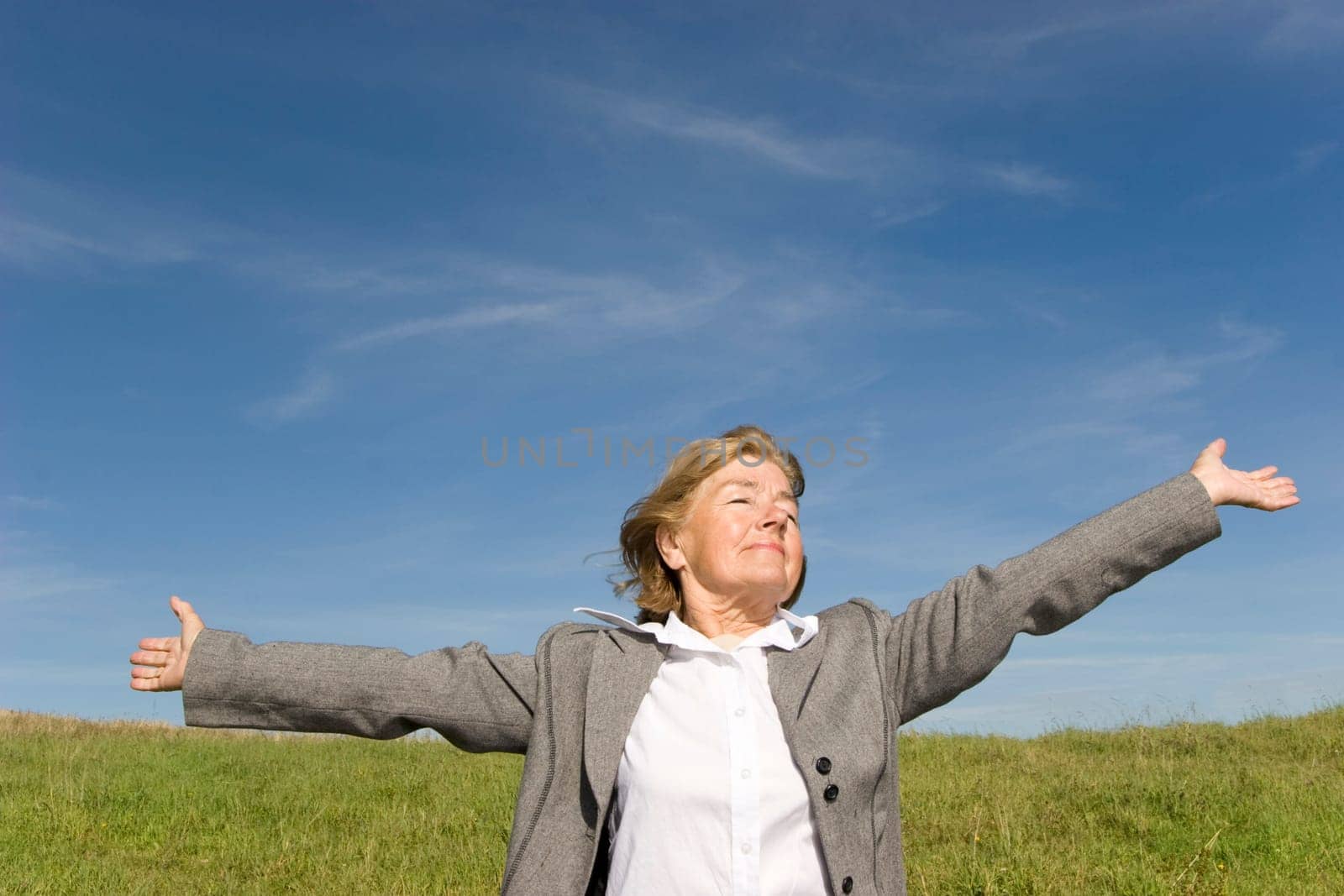 Beautiful, joyful mature woman on the meadow
