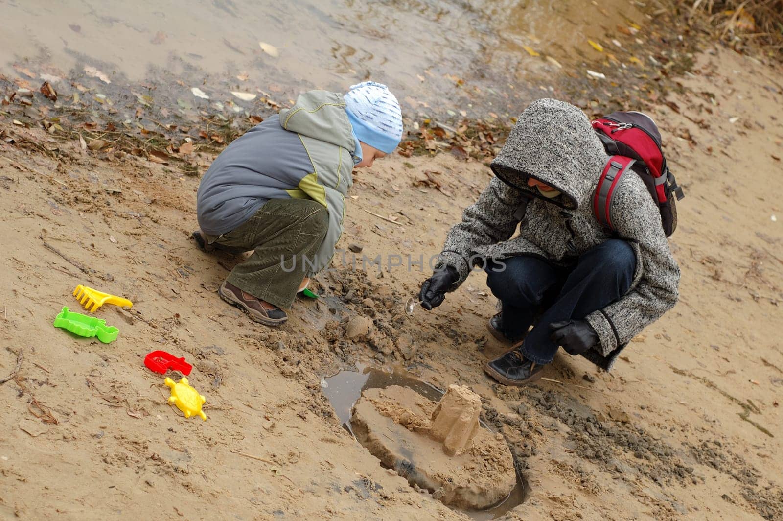 Child playing with his mother on shore/bank