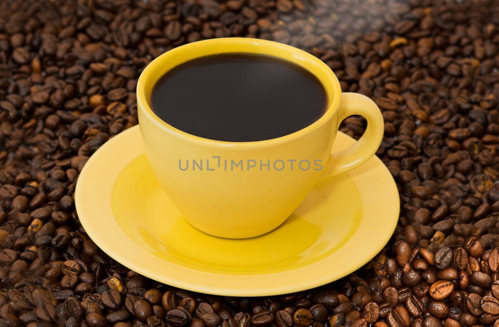 The warm cup of coffe on coffe-grass background