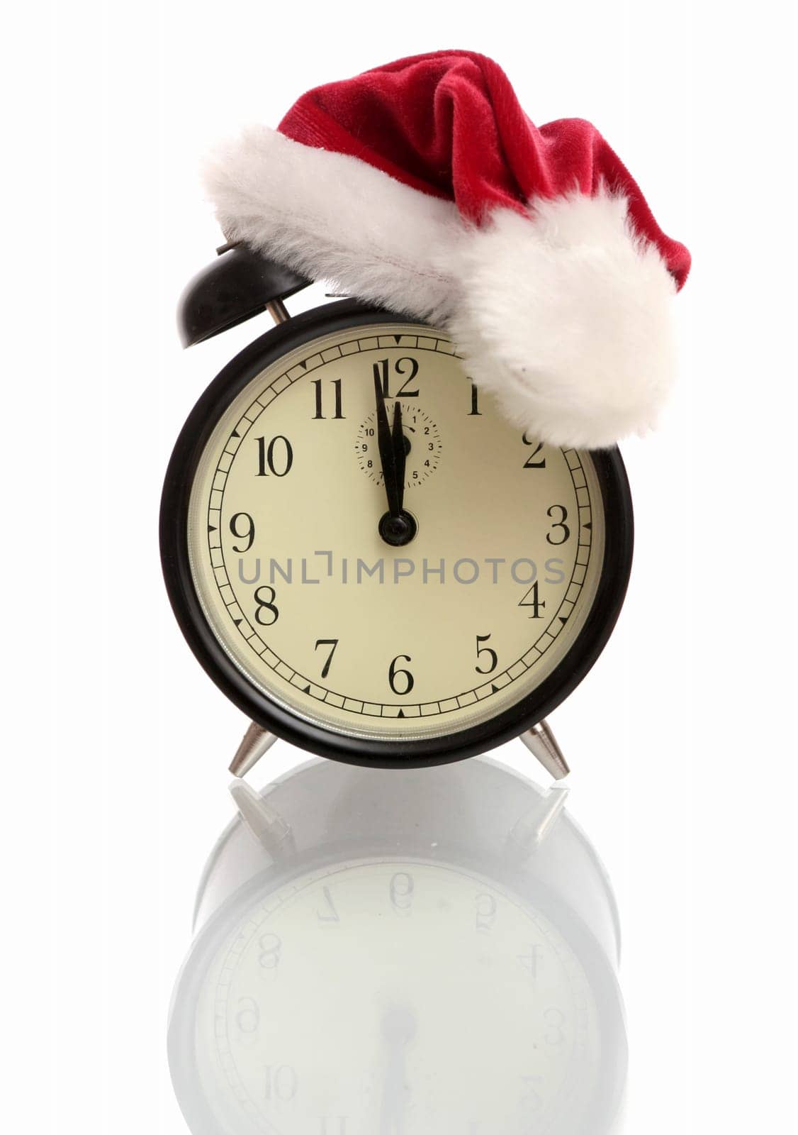 Black alarm clock in a New Year's cap on a white background