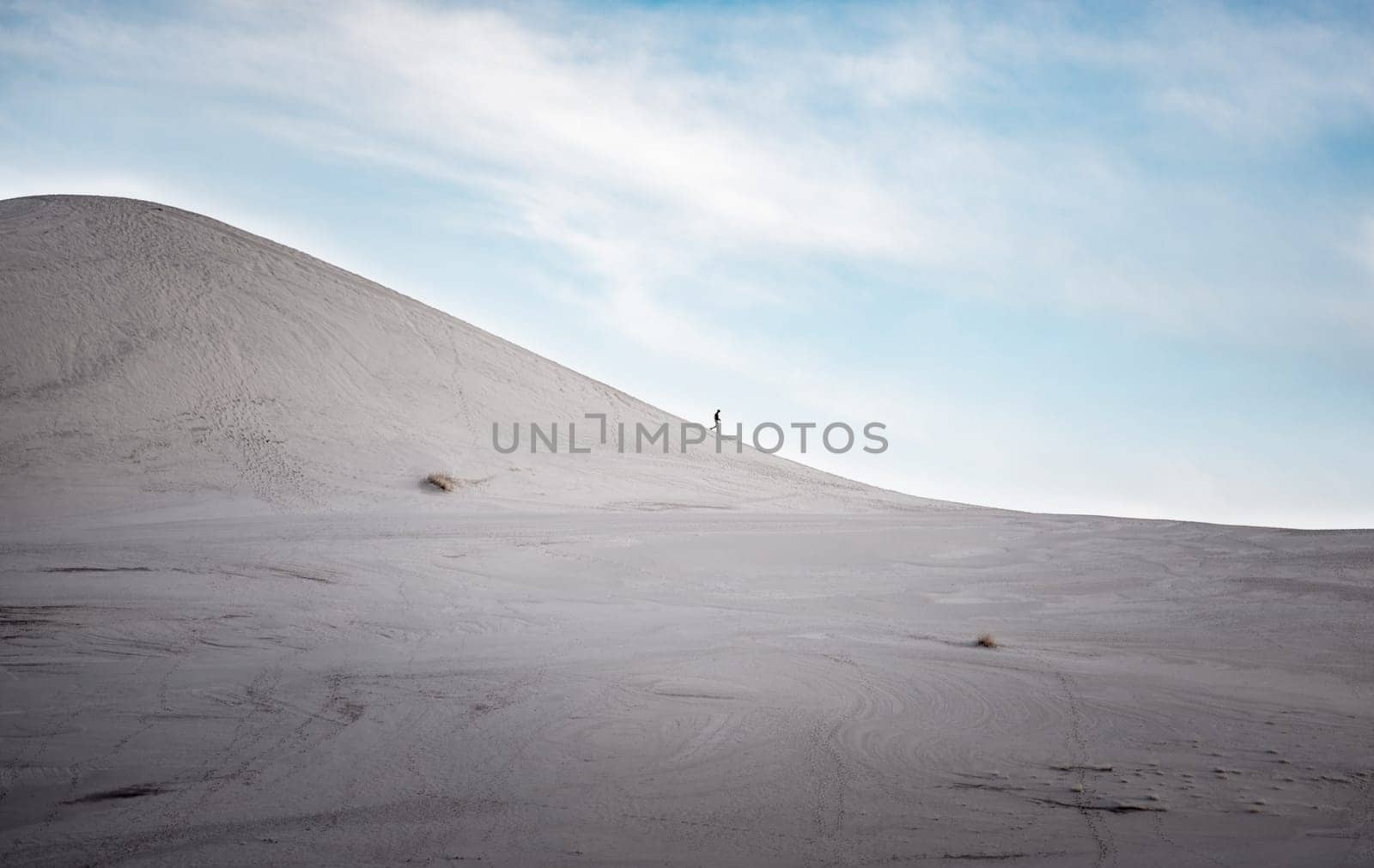 Lonely Hiker profile descending a and dune.