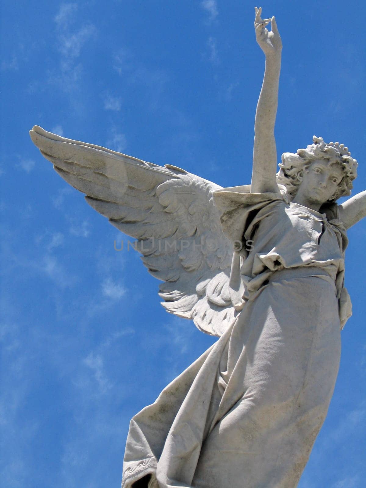 detail of winged angel statue against blue sky