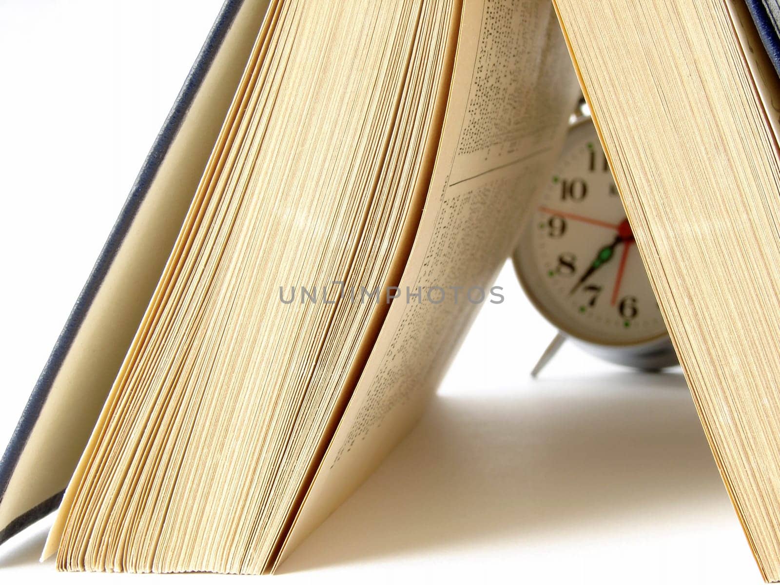 open book and classic alarm clock